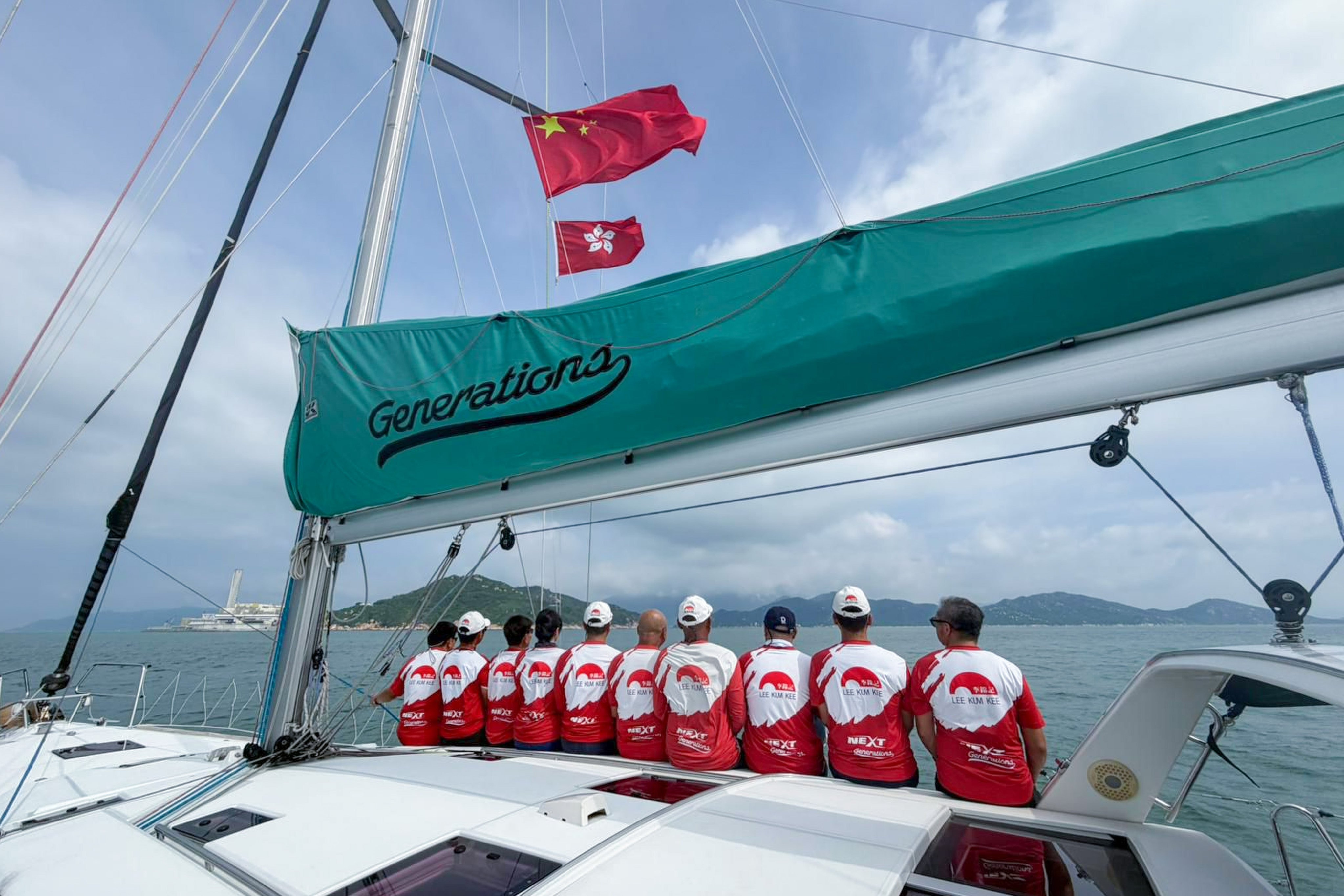 Crew members of the Hong Kong yacht Generations line the deck as they approach mainland waters. Photo: Handout