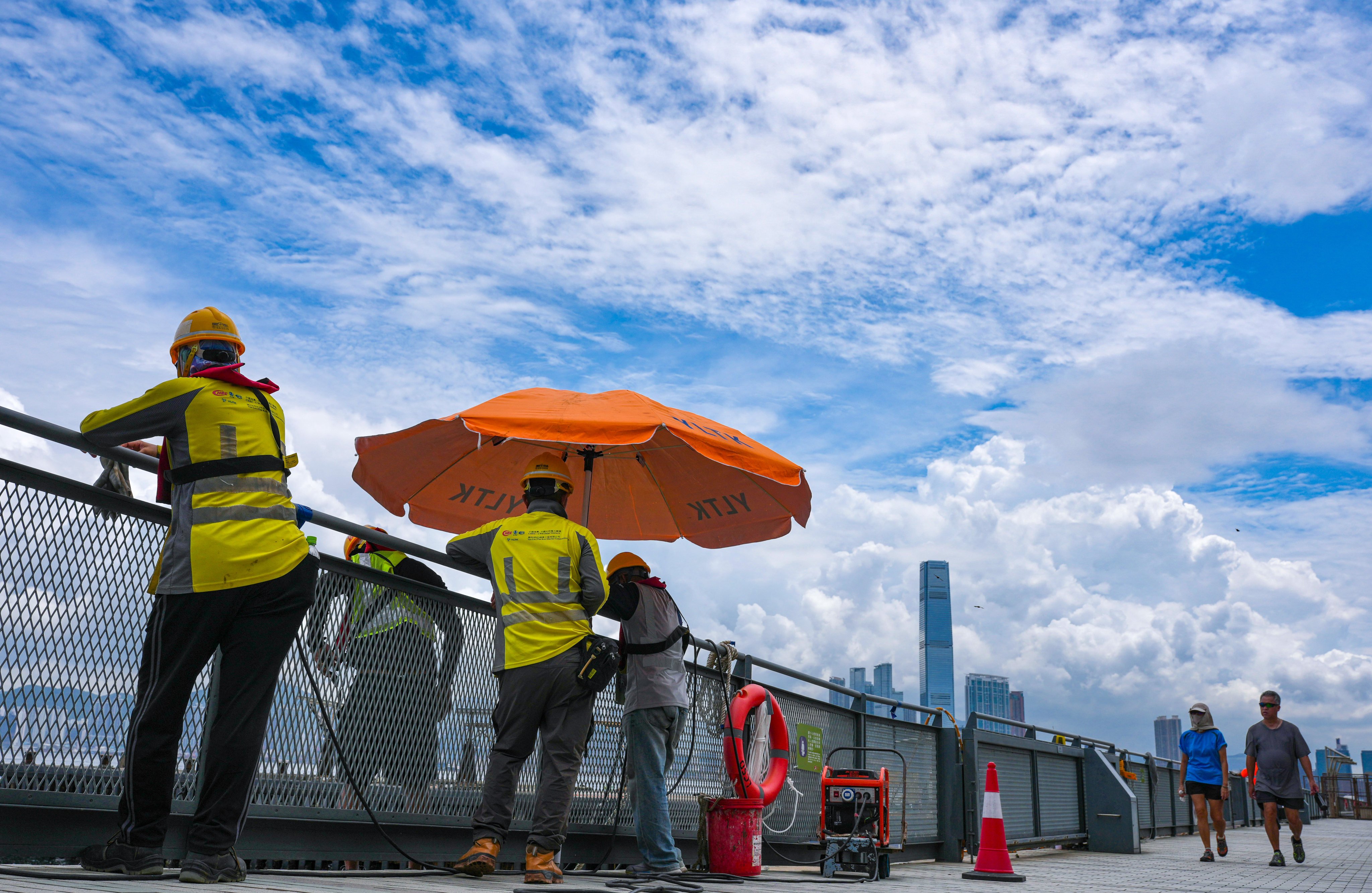 Workers at the Sai Ying Pun Harbourfront promenade. Hong Kong is studying the performance of a revamped heat warning system, the labour chief has said. Photo: Karma Lo