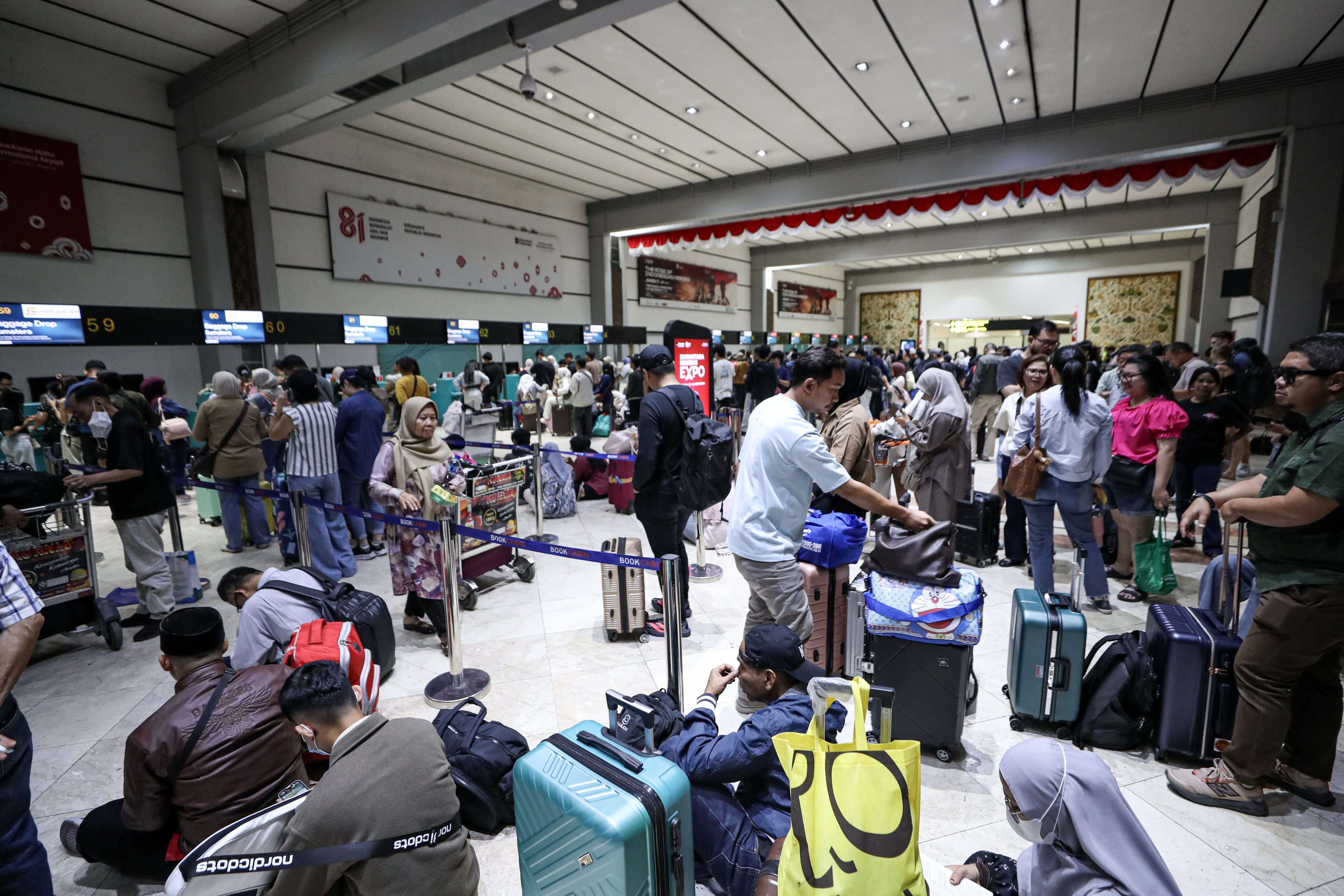 Passengers wait in the check-in lounge as flights are cancelled at Soekarno-Hatta International Airport in Indonesia on Sunday. Photo: EPA