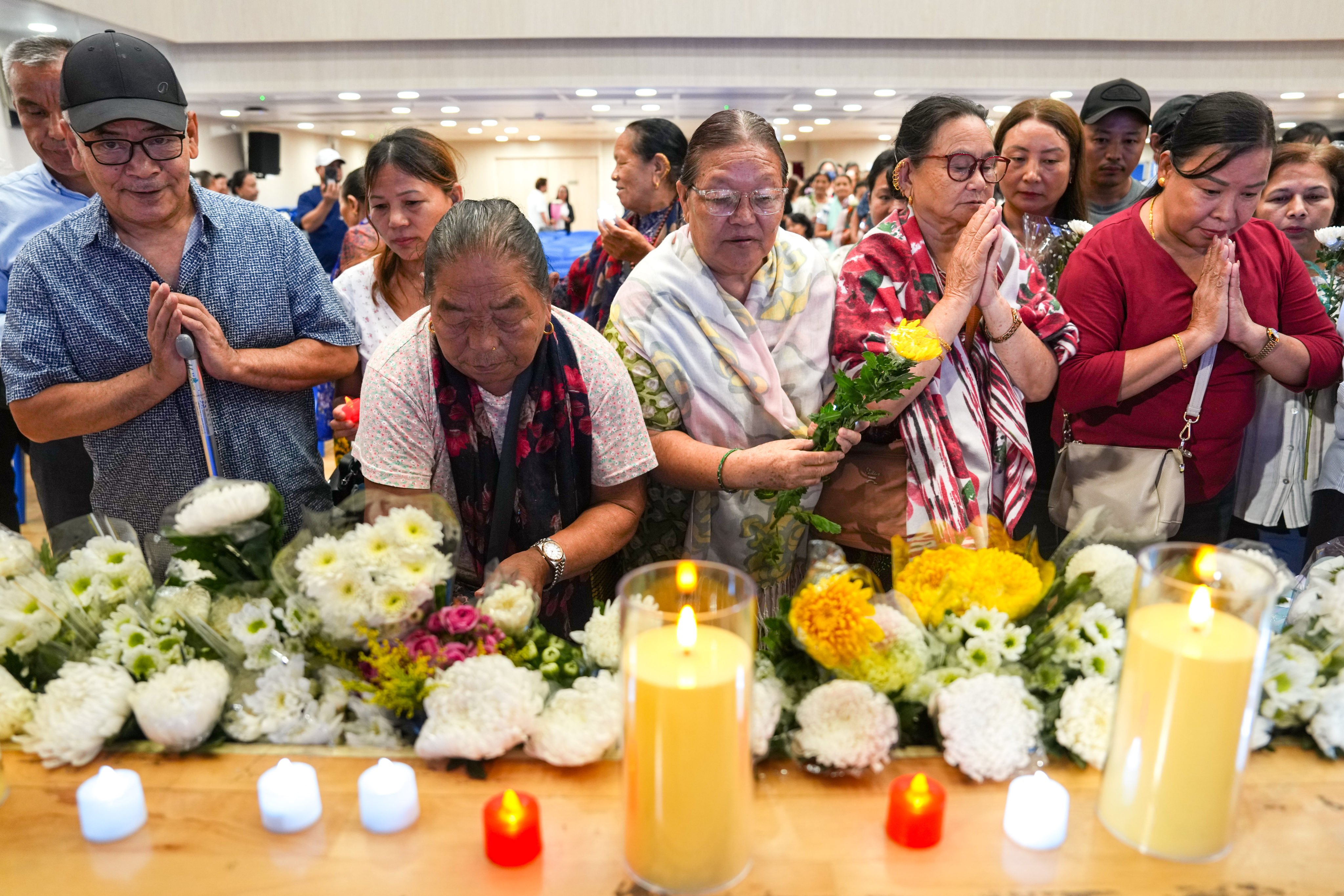 Attendees offer prayers and light candles at the Henry G Leong Community Hall in Yau Ma Tei.  Photo: Kit Lai