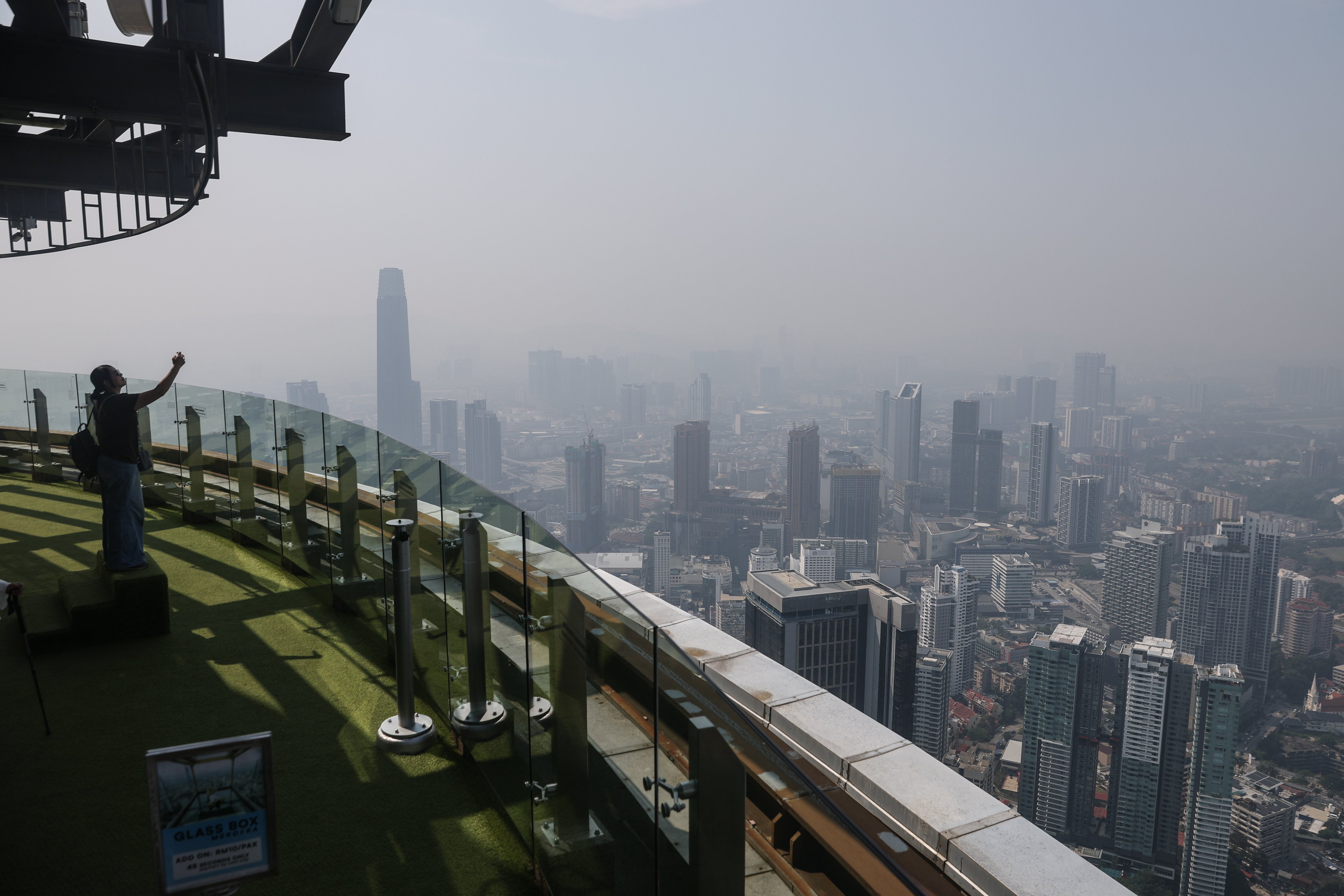 A visitor photographs the city skyline blanketed in haze in Kuala Lumpur, Malaysia, on Monday. Photo: EPA