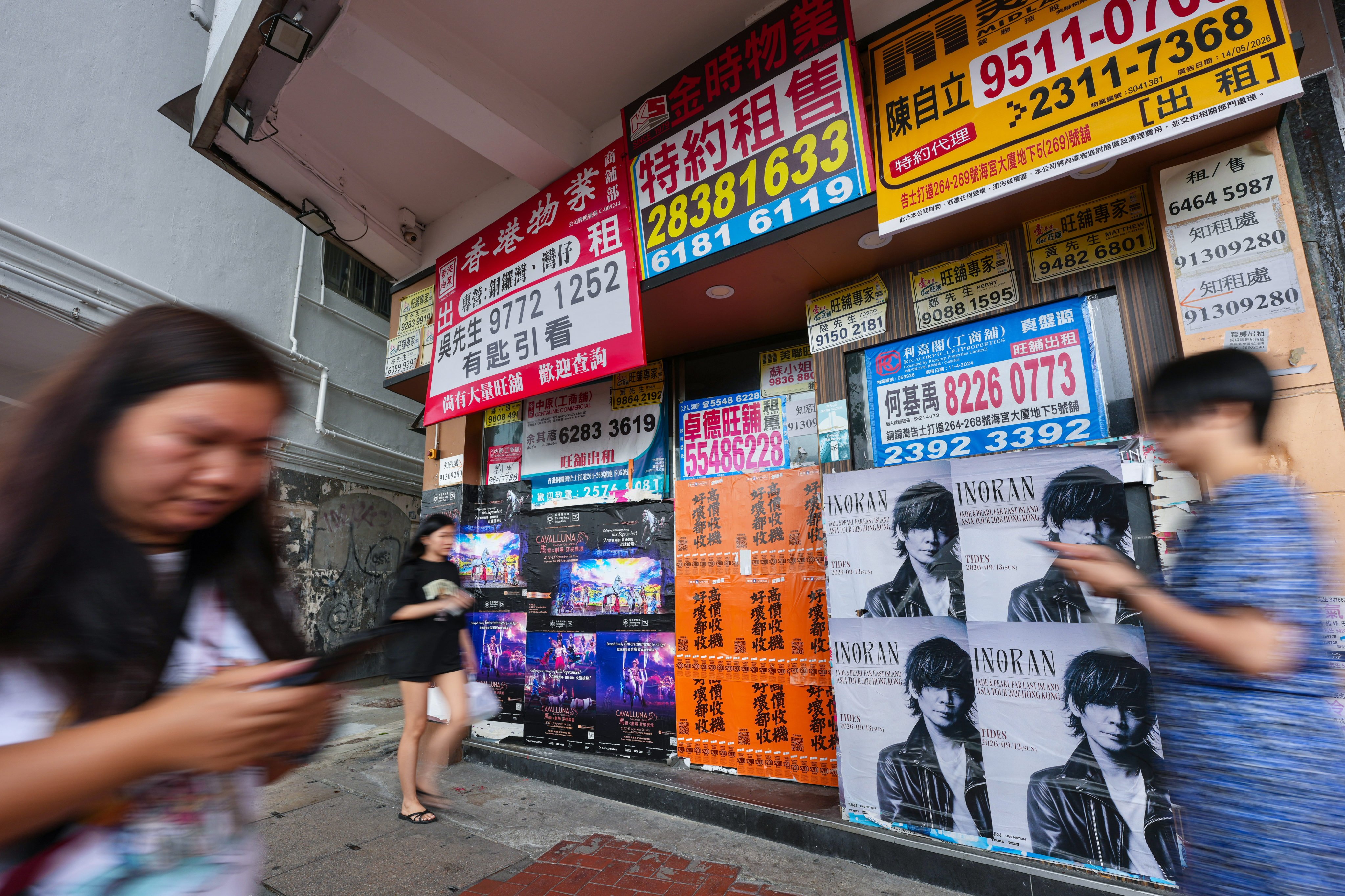 Pedestrians walk past a vacant retail shop plastered with “for lease” posters on Gloucester Road in Causeway Bay on September 6. Photo: Karma Lo