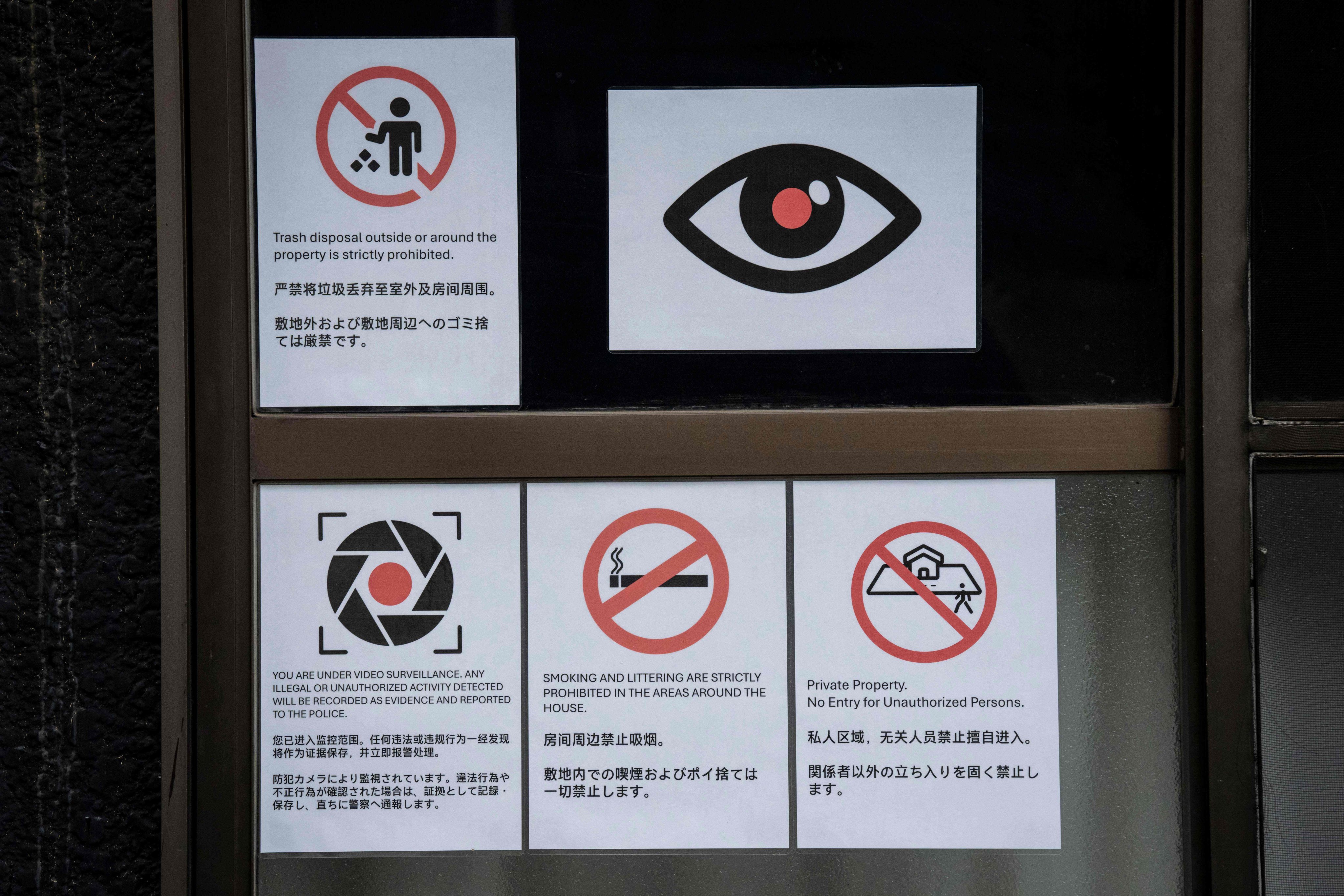 Notices warning against littering, smoking, and unauthorised entry, written in multiple languages, are seen outside a residential building near Shinjuku station in Tokyo on Monday. Photo: AFP