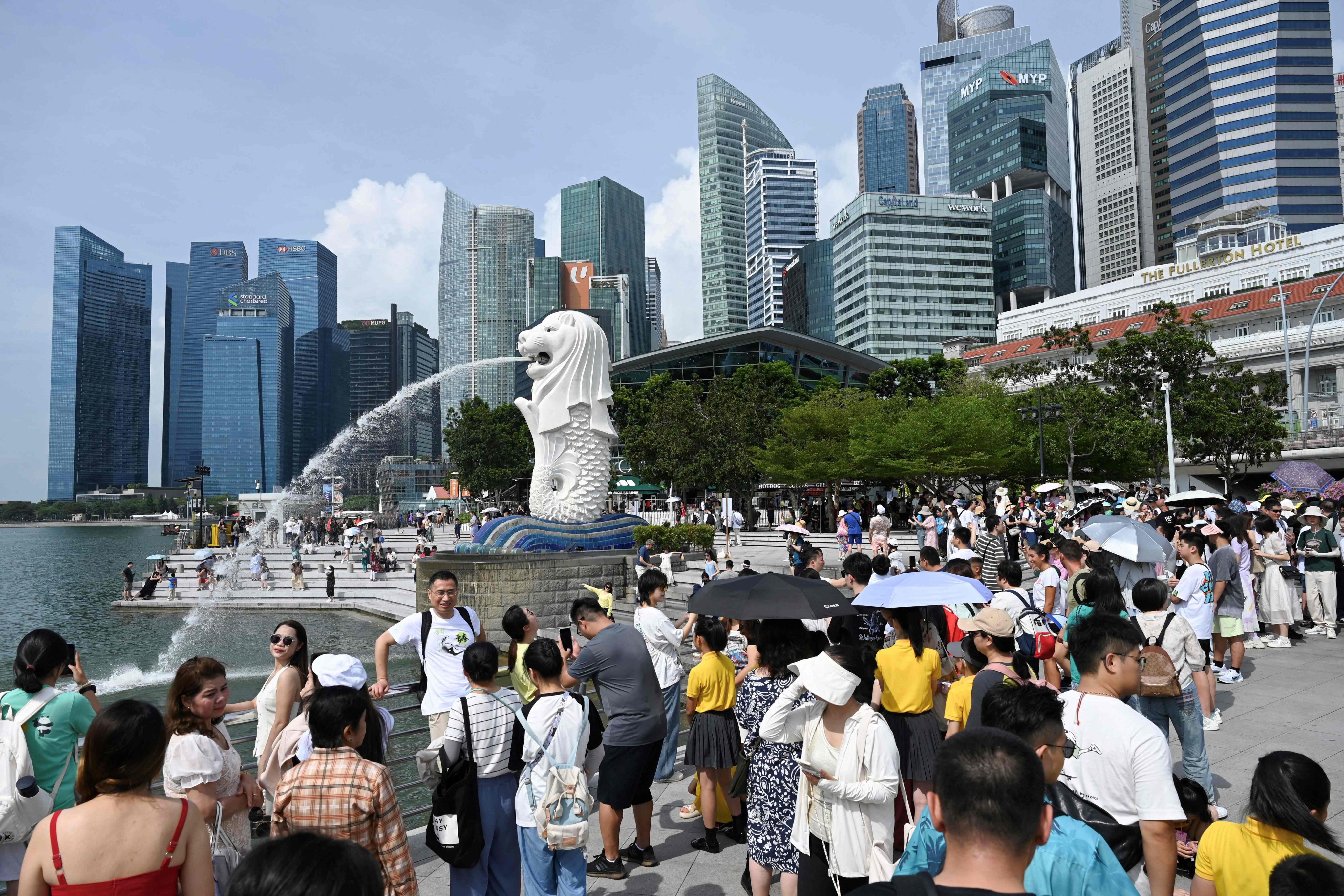 People gather near the Merlion statue at the Marina Bay Waterfront Promenade in Singapore in August 2024. Photo: AFP