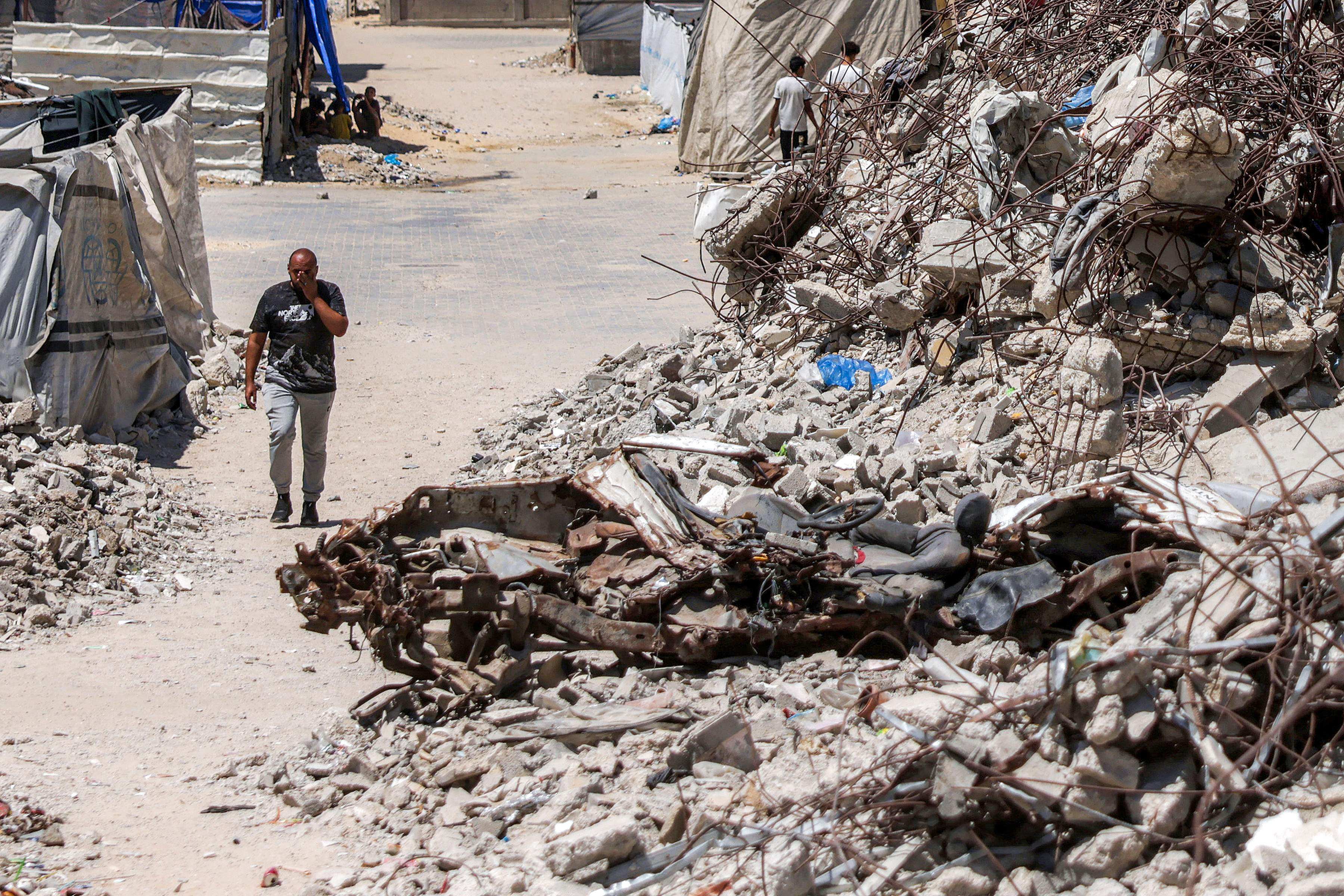 A man walks past the rubble of collapsed buildings in Khan Younis in the southern Gaza Strip on August 25. Photo: AFP