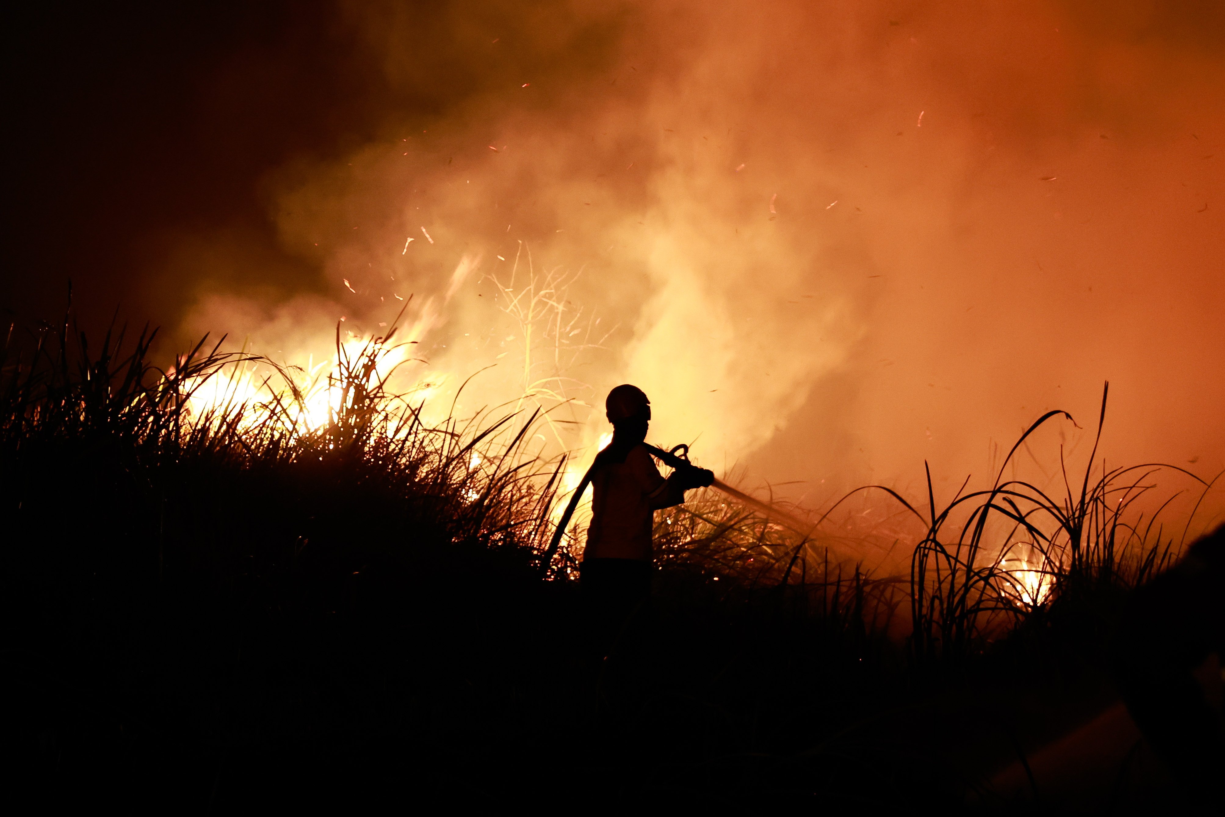 A firefighter sprays water in South Sumatra, Indonesia, on Saturday. Indonesian authorities have intensified response operations as wildfires across Sumatra and Kalimantan generate toxic transboundary haze, affecting neighboring Malaysia, Singapore, and the Philippines. Photo: EPA