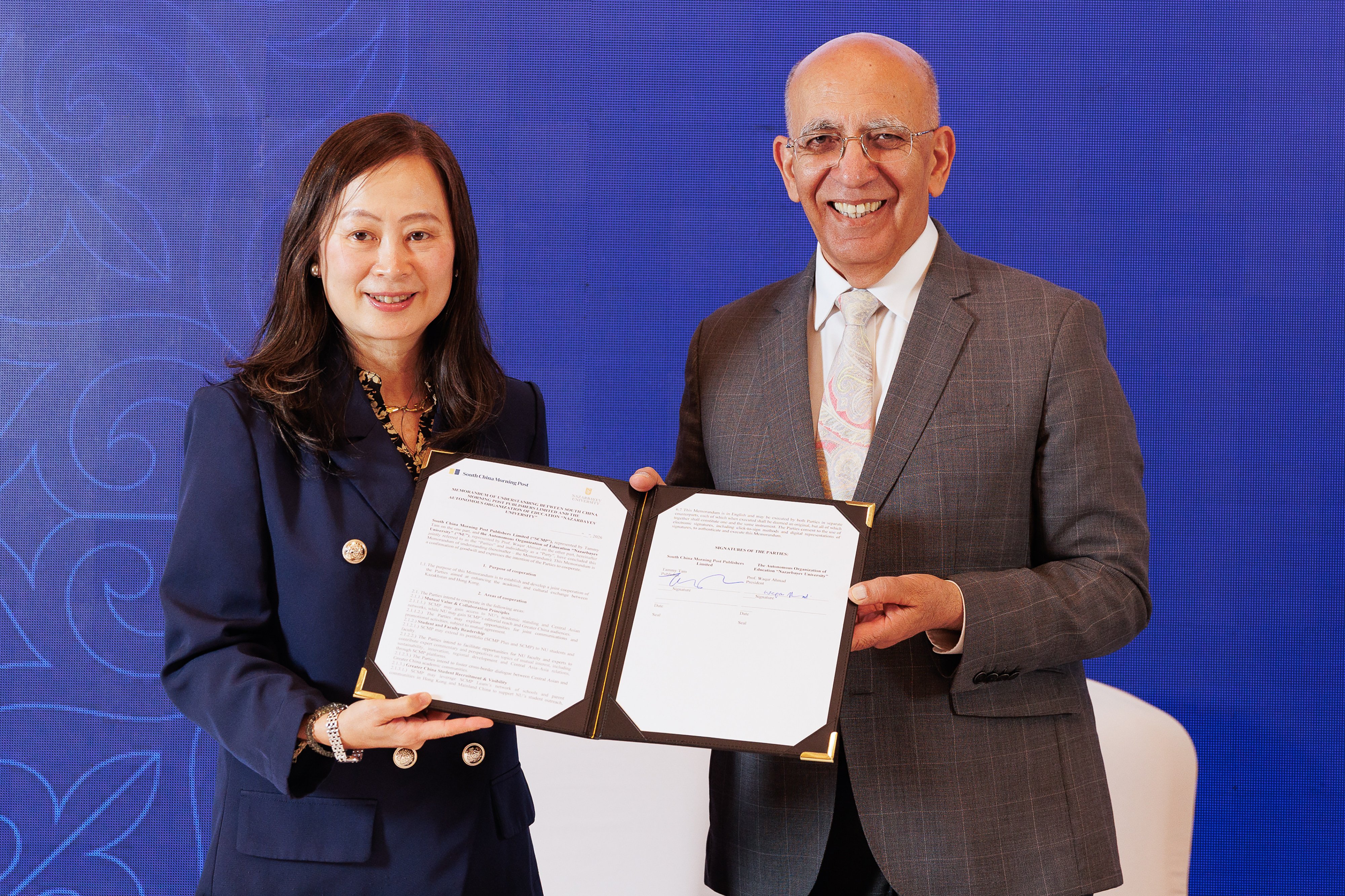 SCMP publisher Tammy Tam (left) and Professor Waqar Ahmad hold the signed MOU in Astana. Photo: SCMP