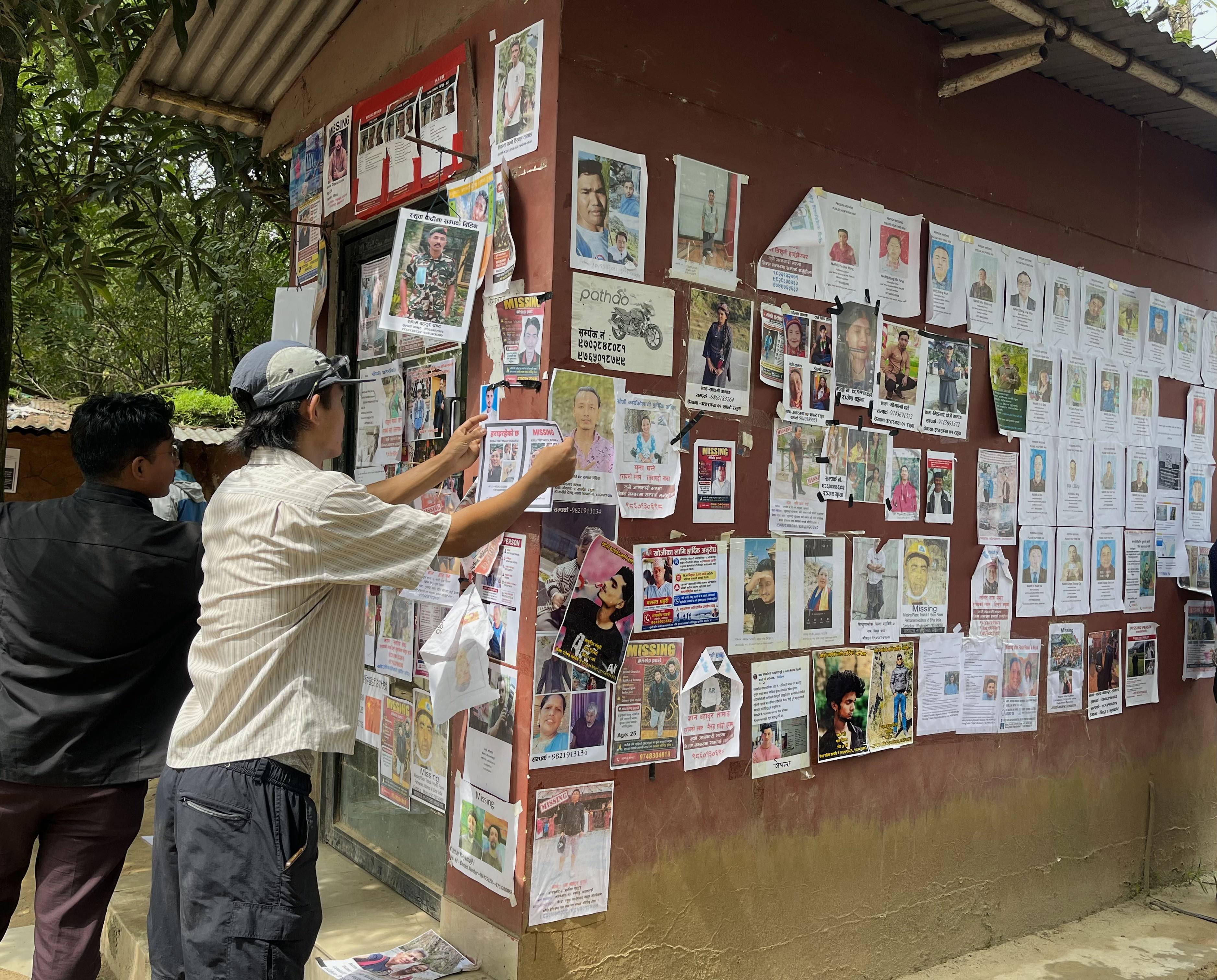 A man sticks a poster of a missing person outside the army camp in Bidur, Nuwakot, Nepal. Photo: Bibek Bhandari
