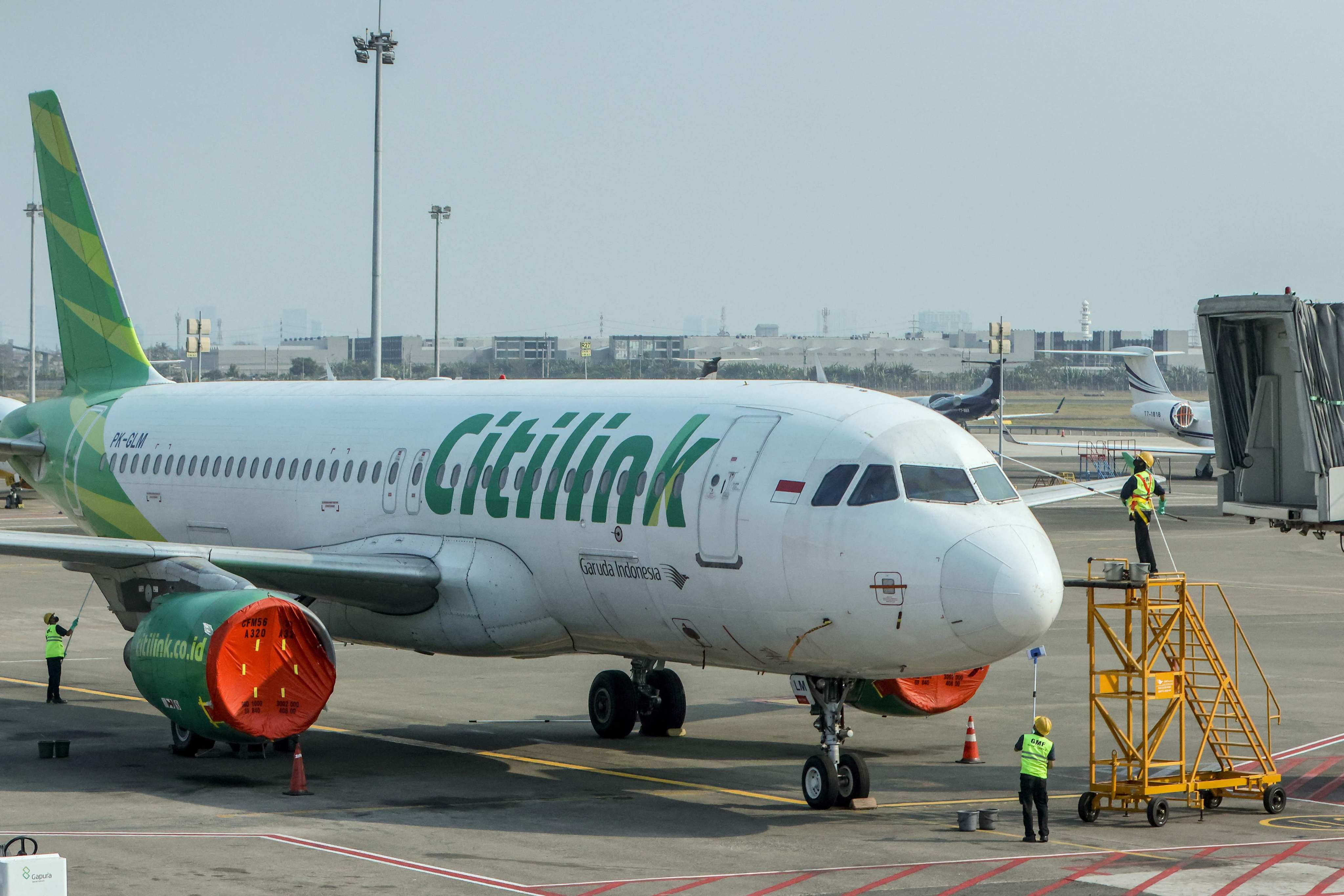 Workers wipe down a Citilink aircraft parked at Soekarno-Hatta airport in Indonesia on Monday. Photo: AFP