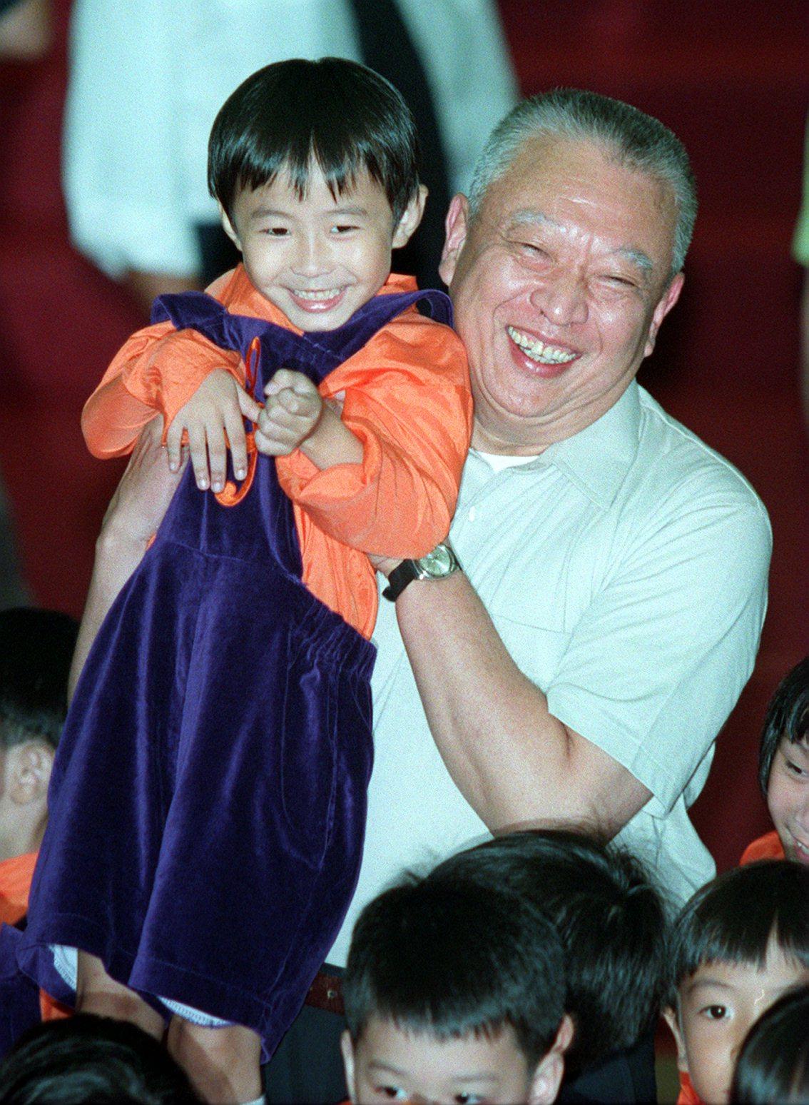 Tung Chee-hwa holds a child during a community visit to Wong Tai Sin in 1997. Photo: Robert Ng