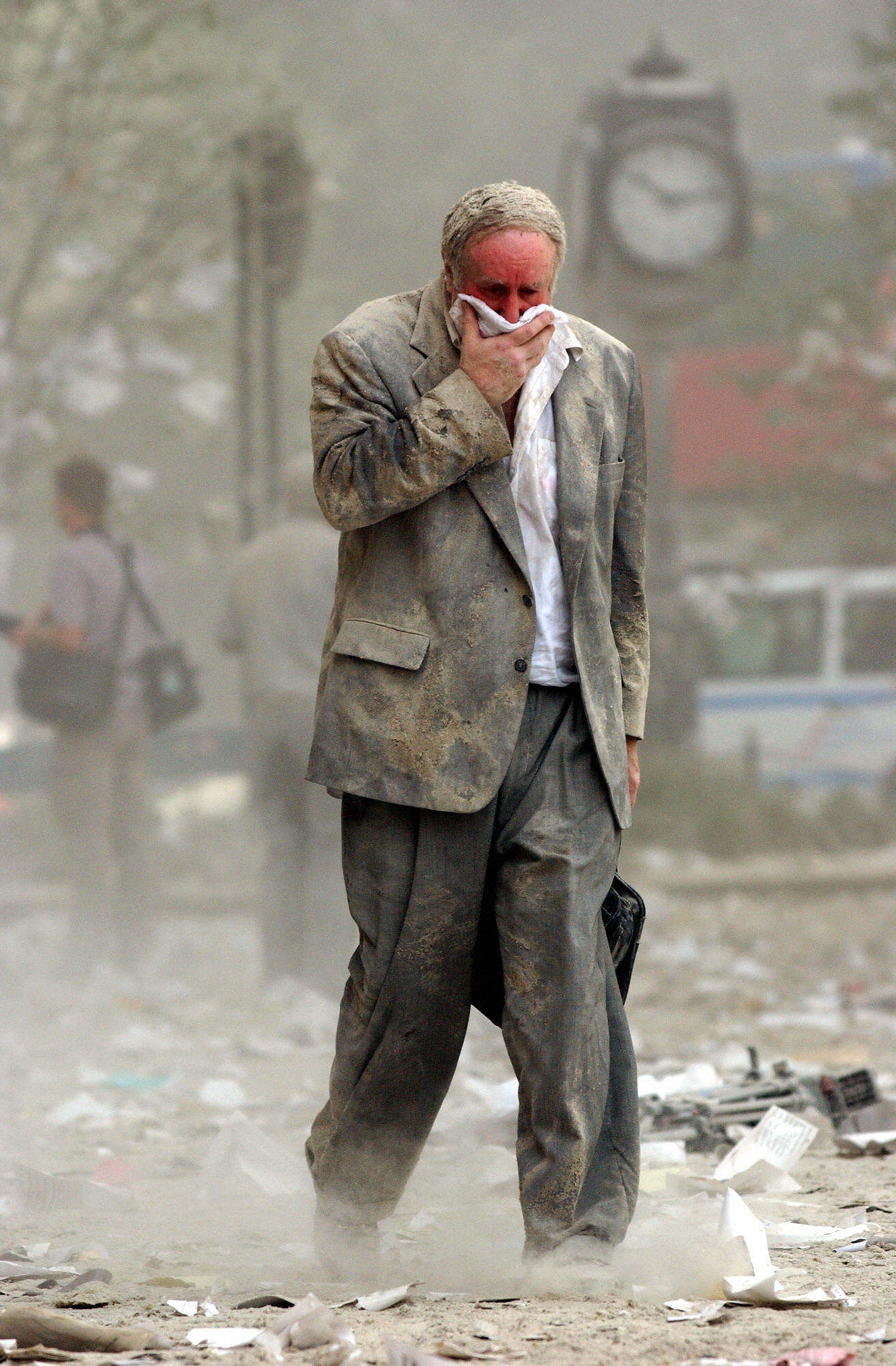 A man covering his mouth as he walks through debris and dust on September 11, 2001. Photo: AFP