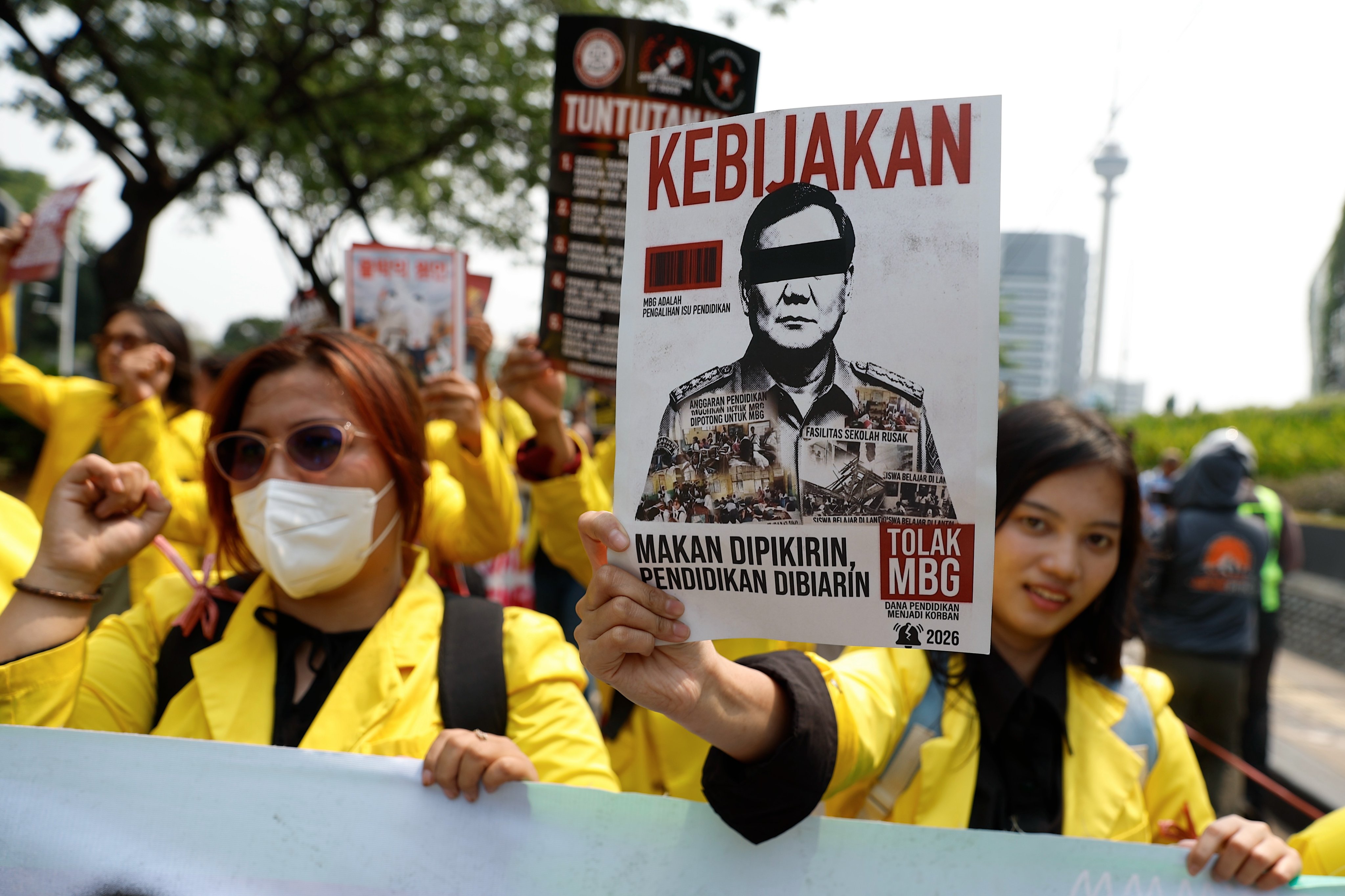 A protester holds a placard rejecting the government’s free meal programme during a protest outside the parliament building in Jakarta on August 27. Photo: EPA