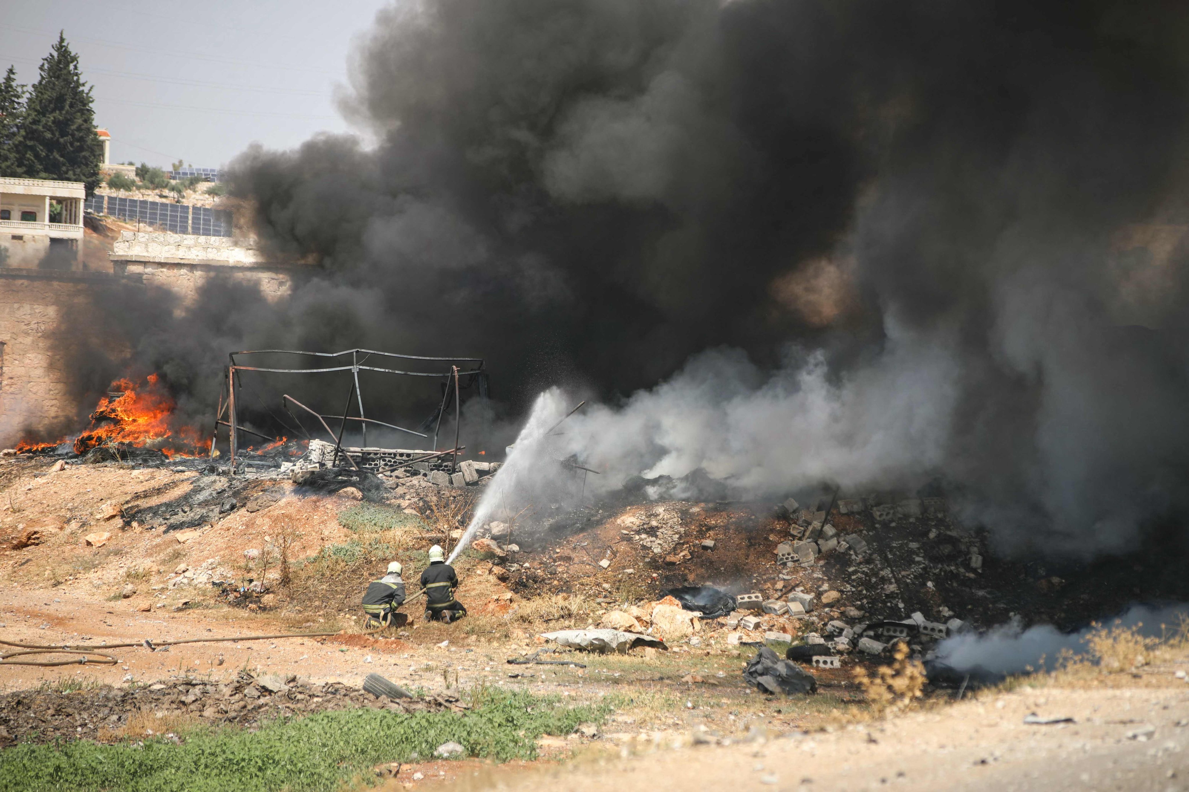 Firefighters douse fire at the site of an explosion that took place at a temporary arms and war ordinance depot in the town of Samarda in Idlib province on Wednesday. Photo: AFP