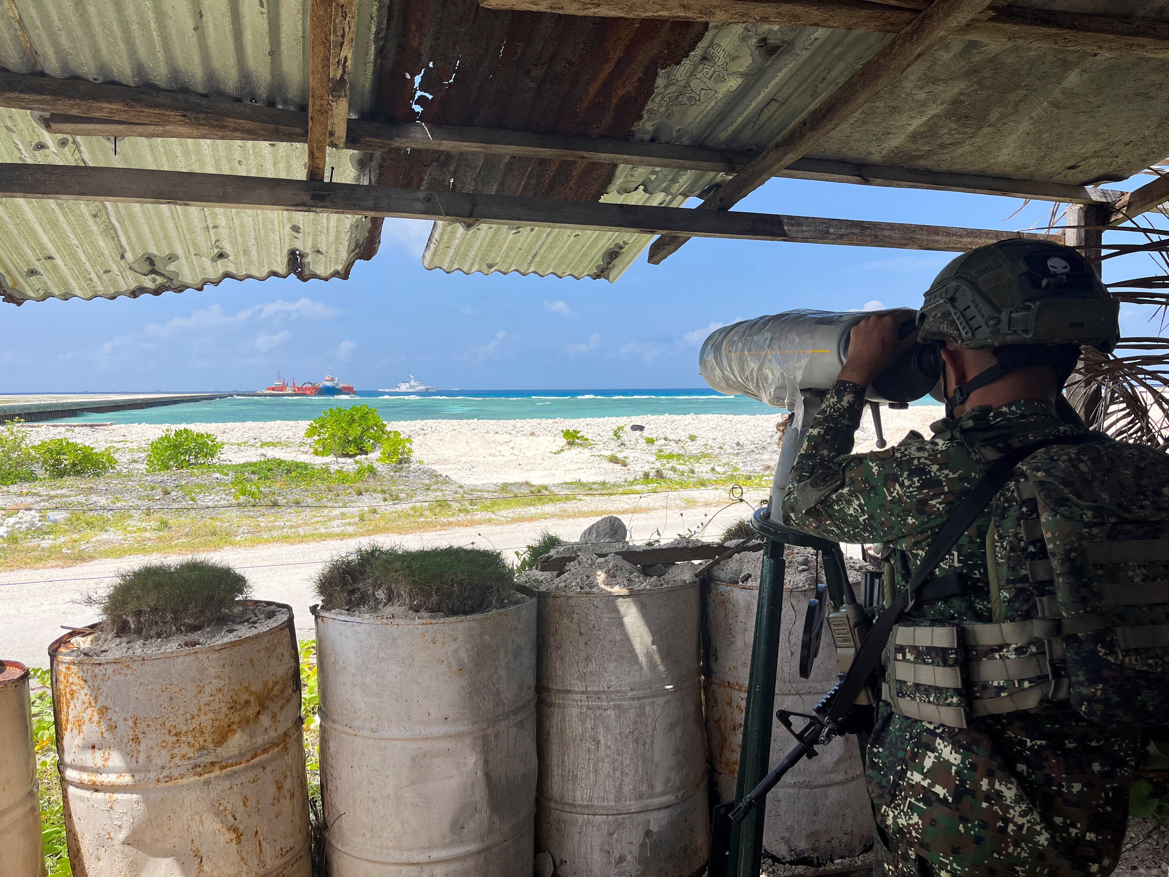 A Philippine soldier peers from a viewing deck in Philippine-occupied Thitu Island in the disputed South China Sea in February. Photo: Reuters