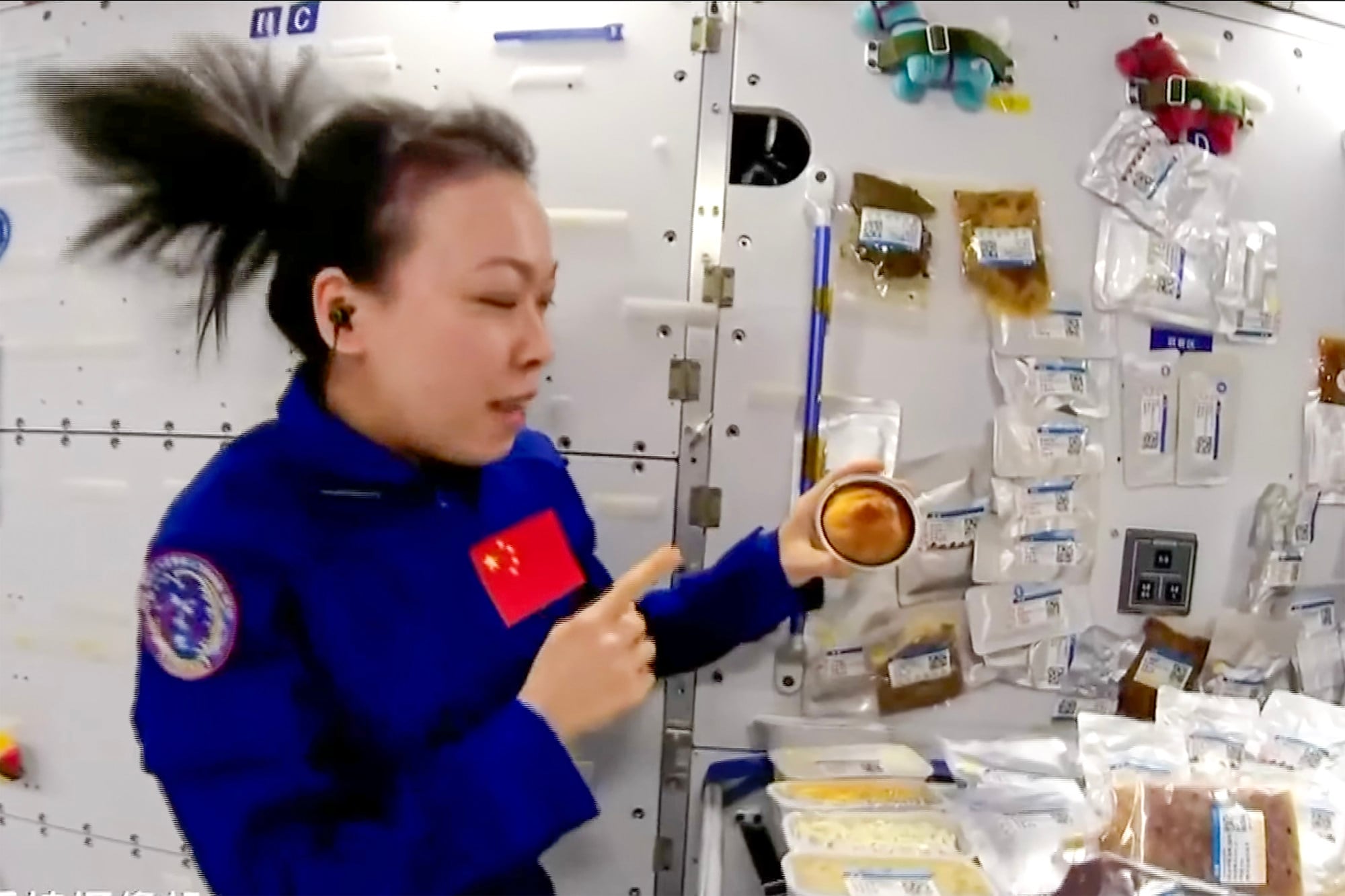 Astronaut Lai Ka-ying holds a mini cake baked in the space station. Photo: YouTube/RTHK