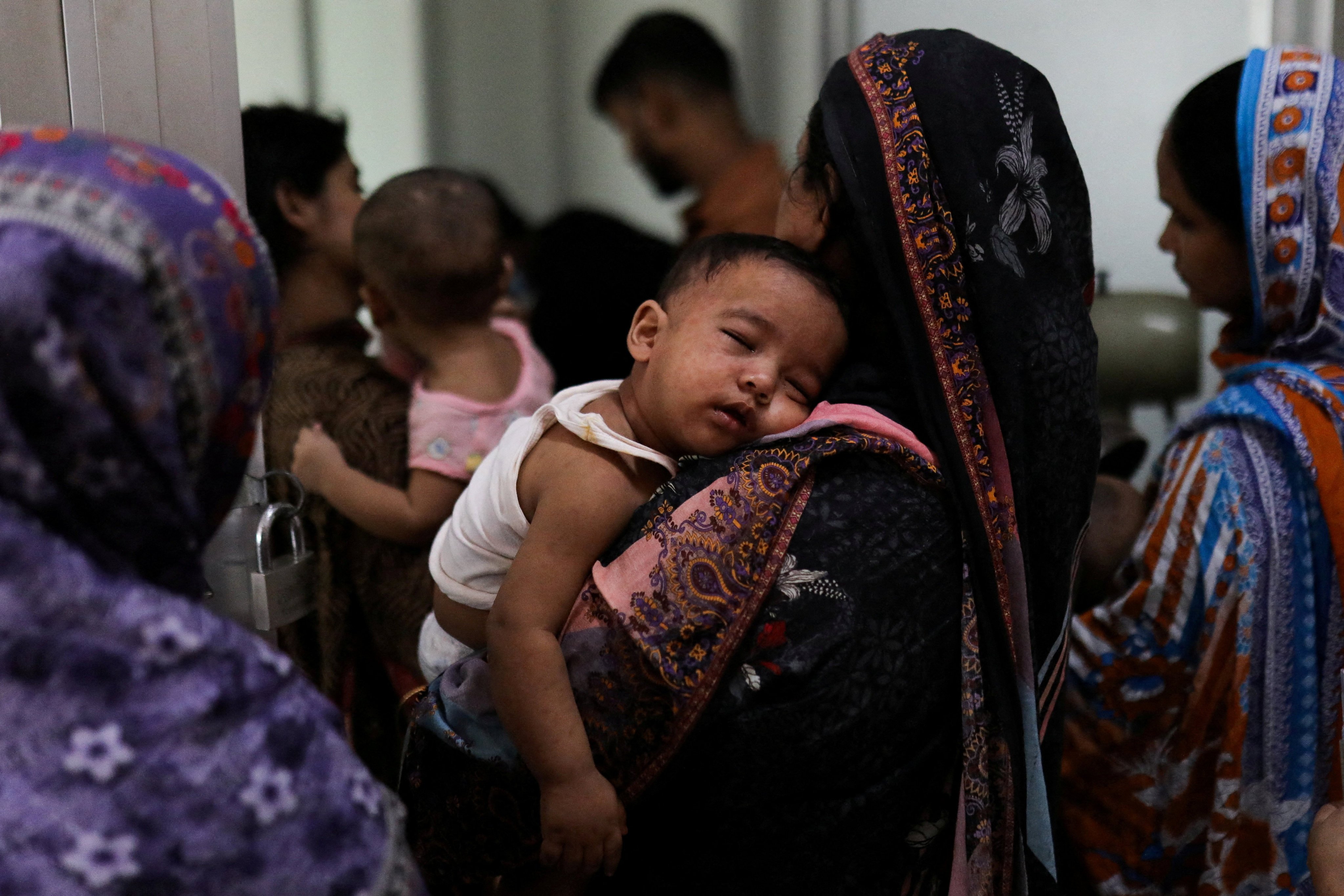 A woman carries a child, who suffers from measles, for treatment at a hospital in Dhaka, Bangladesh, on Monday. Photo: Reuters