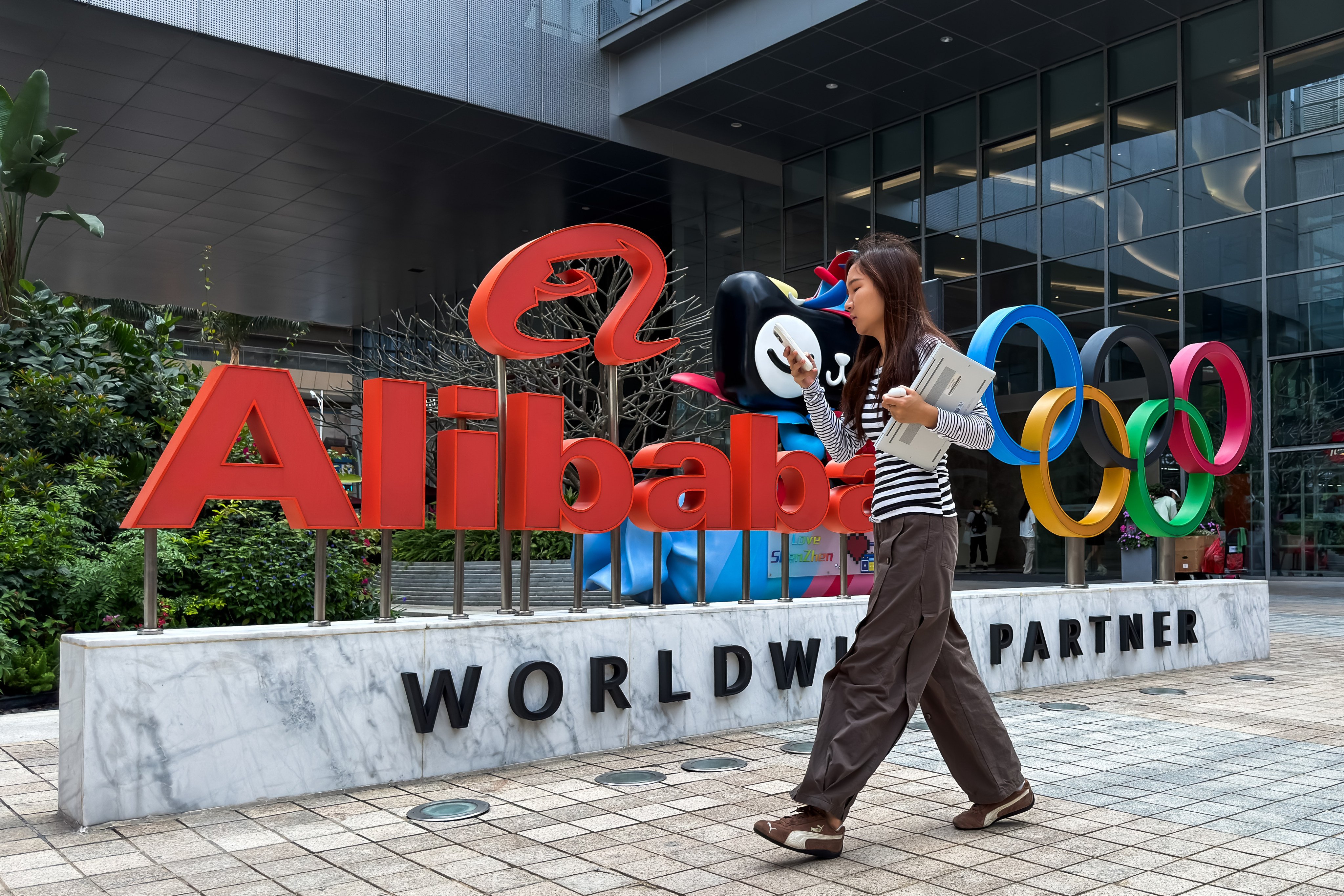 A woman walks past an Alibaba Group sign at an office complex in Shenzhen, in southern China’s Guangdong province, on March 25, 2026. Photo: Getty Images