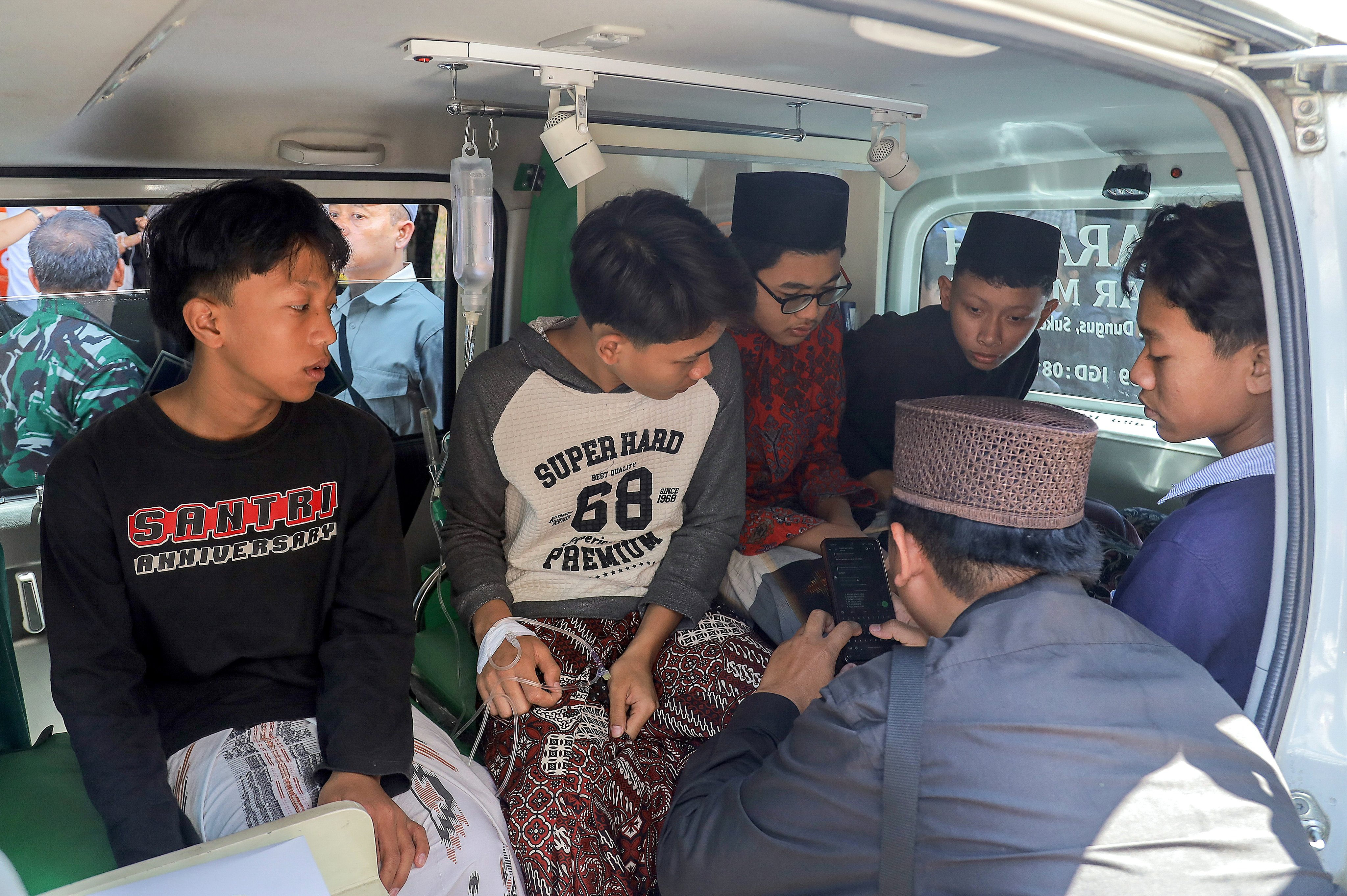 Students suffering from food poisoning await medical treatment in an ambulance at the Manbaul Hikam Islamic boarding school in Sidoarjo on September 2. Photo: EPA