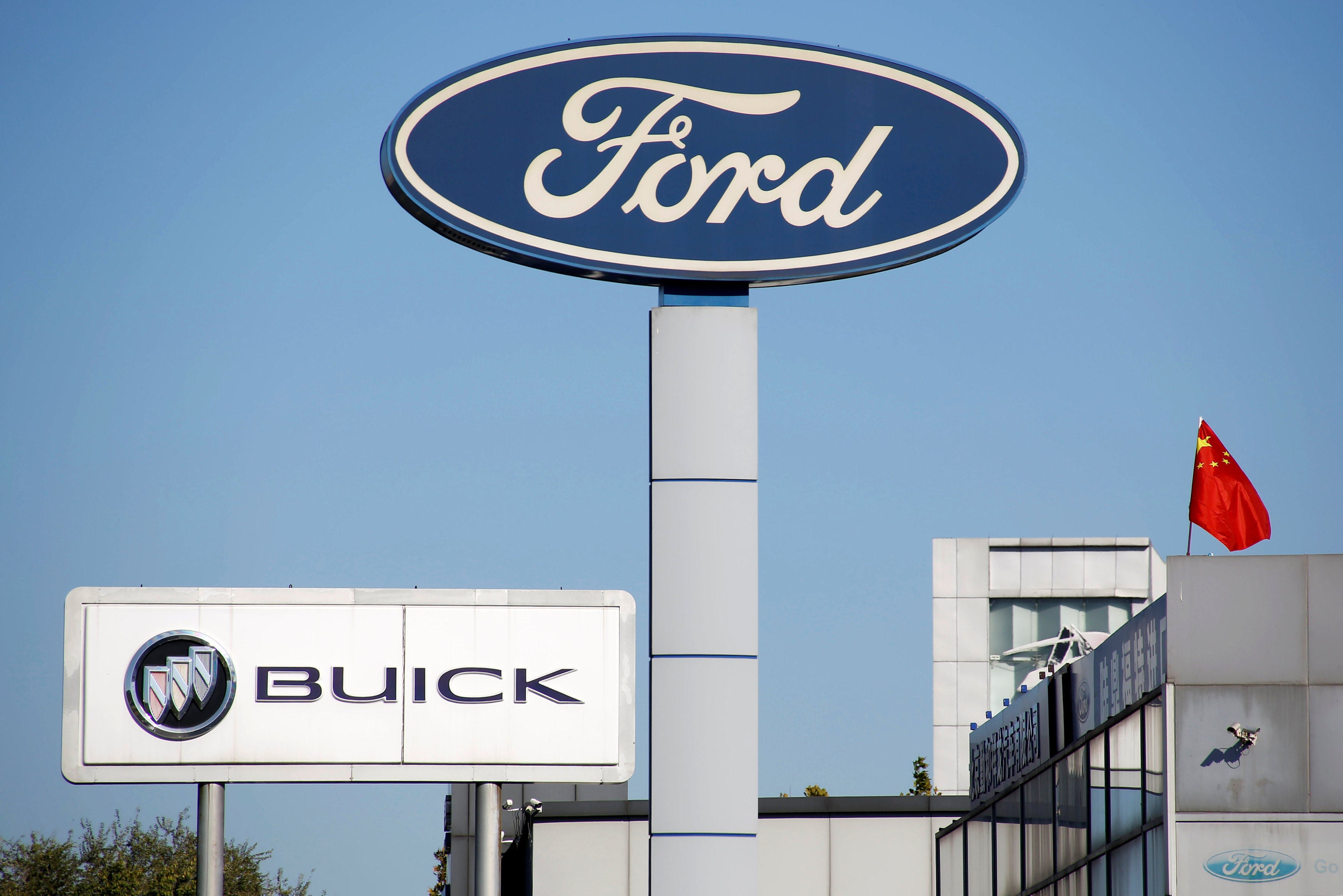 The Chinese national flag flies on the roof of a car dealership near the brand logos of carmakers, including Ford, in Beijing in October 2018. Photo: Reuters