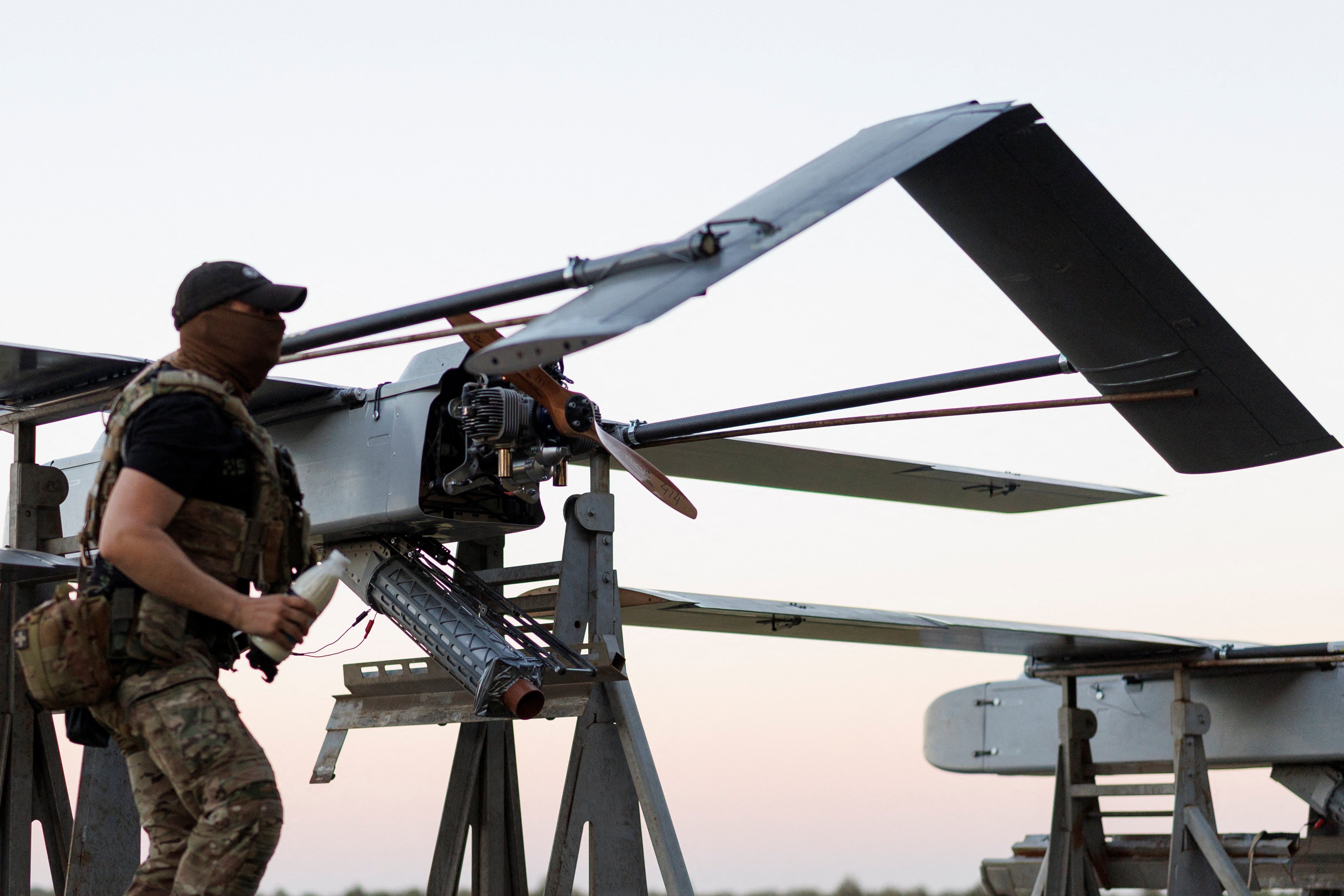A service member of the 414th Separate Unmanned Strike Aviation System Brigade of the Ukrainian Armed Forces checks an FP-1 deep-strike drone before it launches for a combat mission, in an undisclosed location in Ukraine, in 2026. Photo: Reuters