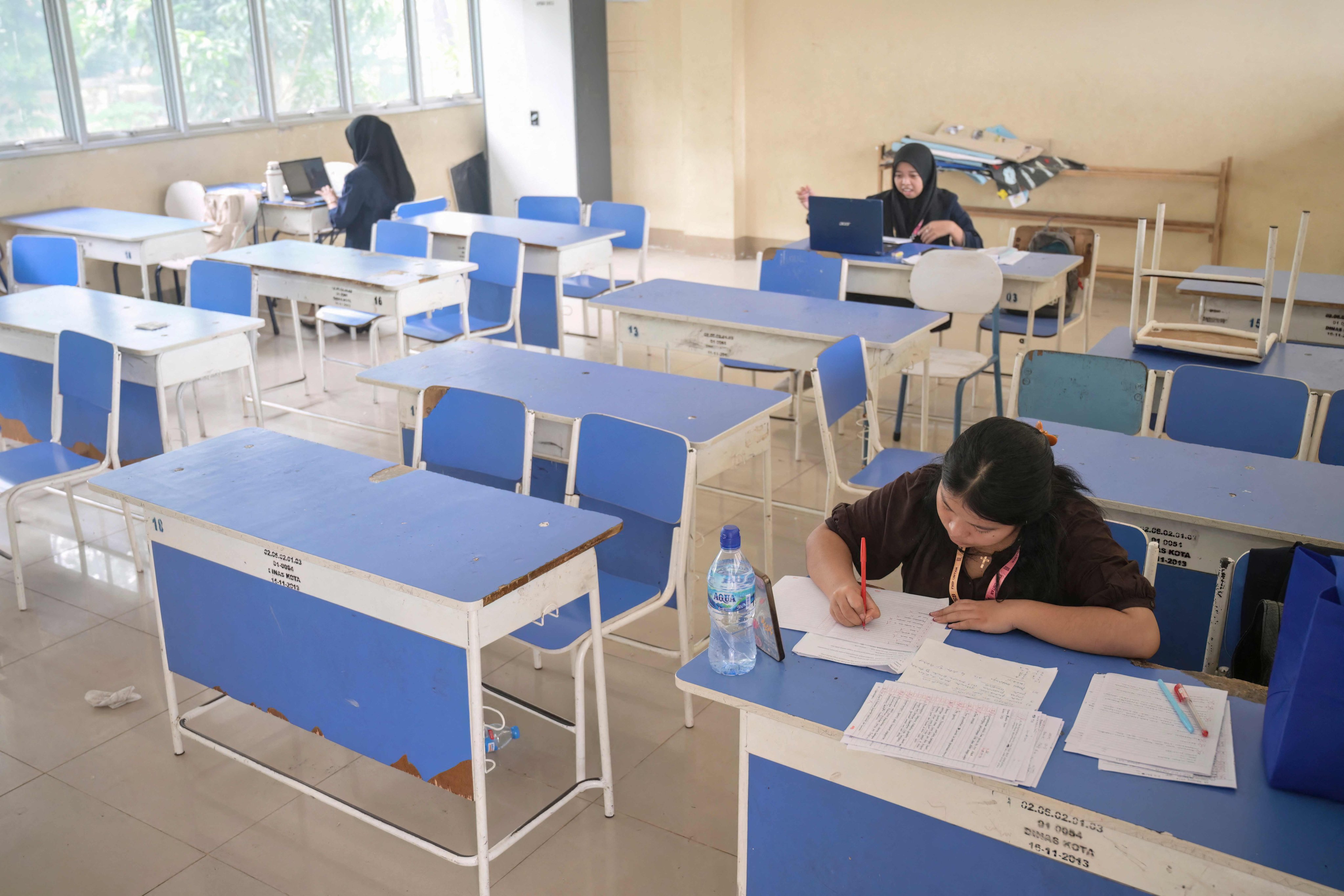Junior high school teachers conduct online lessons in an empty classroom after local authorities mandated remote learning due to haze from land and forest fires in West Kalimantan, Indonesia, on Monday. Photo: AFP