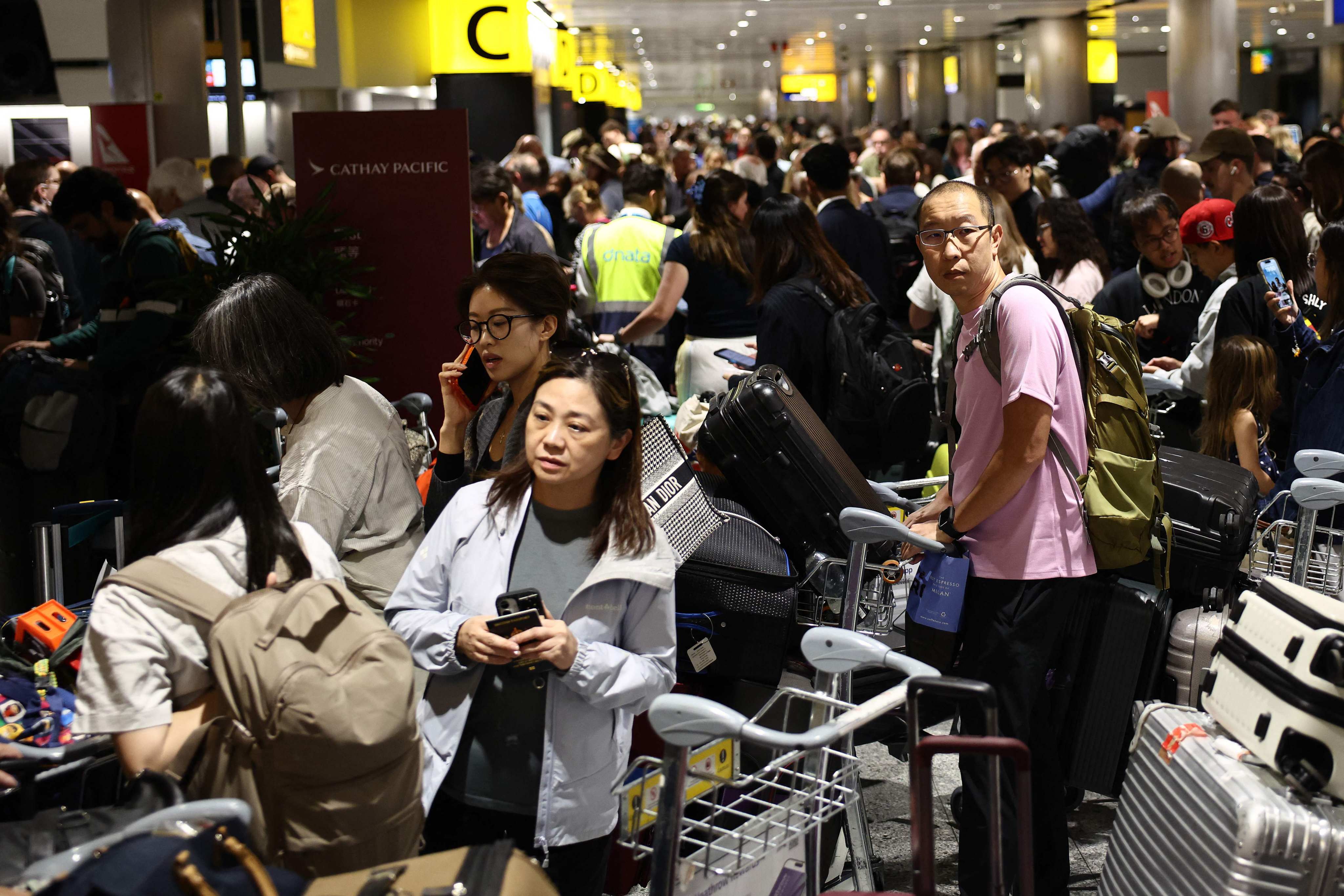 Passengers queue with their luggage at Terminal 3 of London Heathrow airport on Tuesday. Photo: AFP