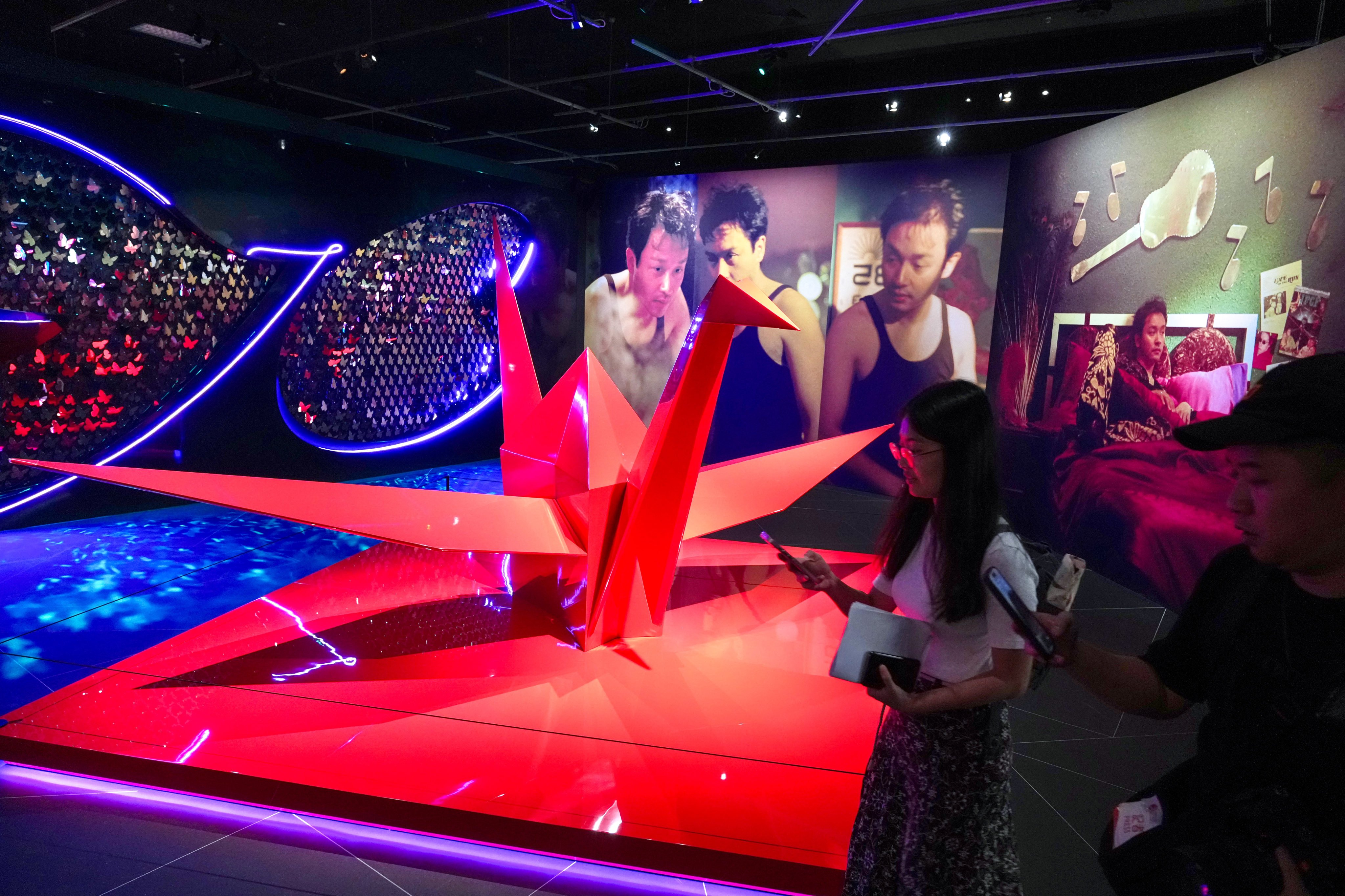 An origami crane sculpture and a dynamic butterfly projection art installation are displayed at the entrance of the exhibition. Photo: Karma Lo