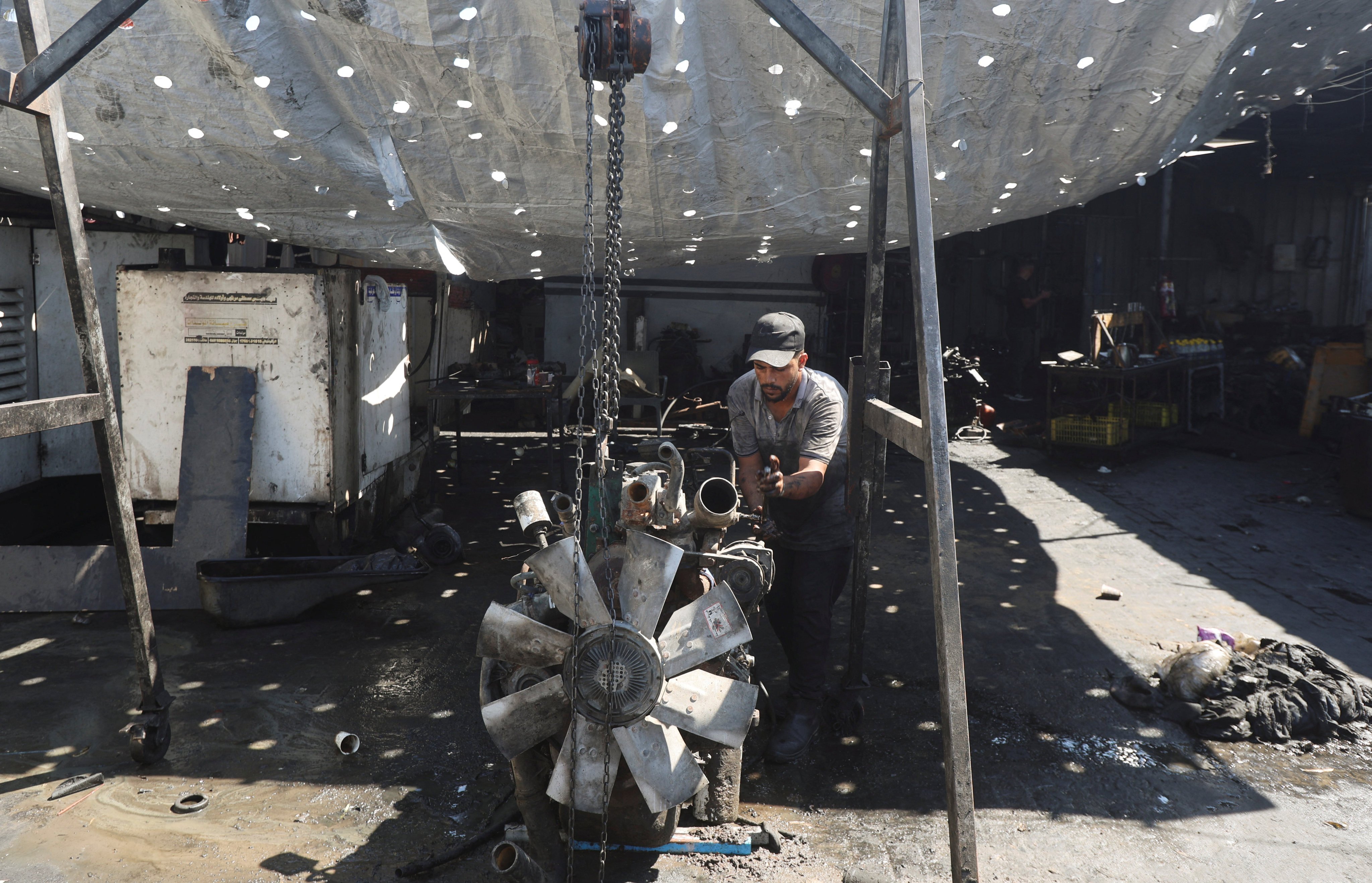 A Palestinian man repairs a power generator needed to run generators, amid shortages of fuel and oil, in Khan Younis, in the southern Gaza Strip, on September 5. Photo: Reuters