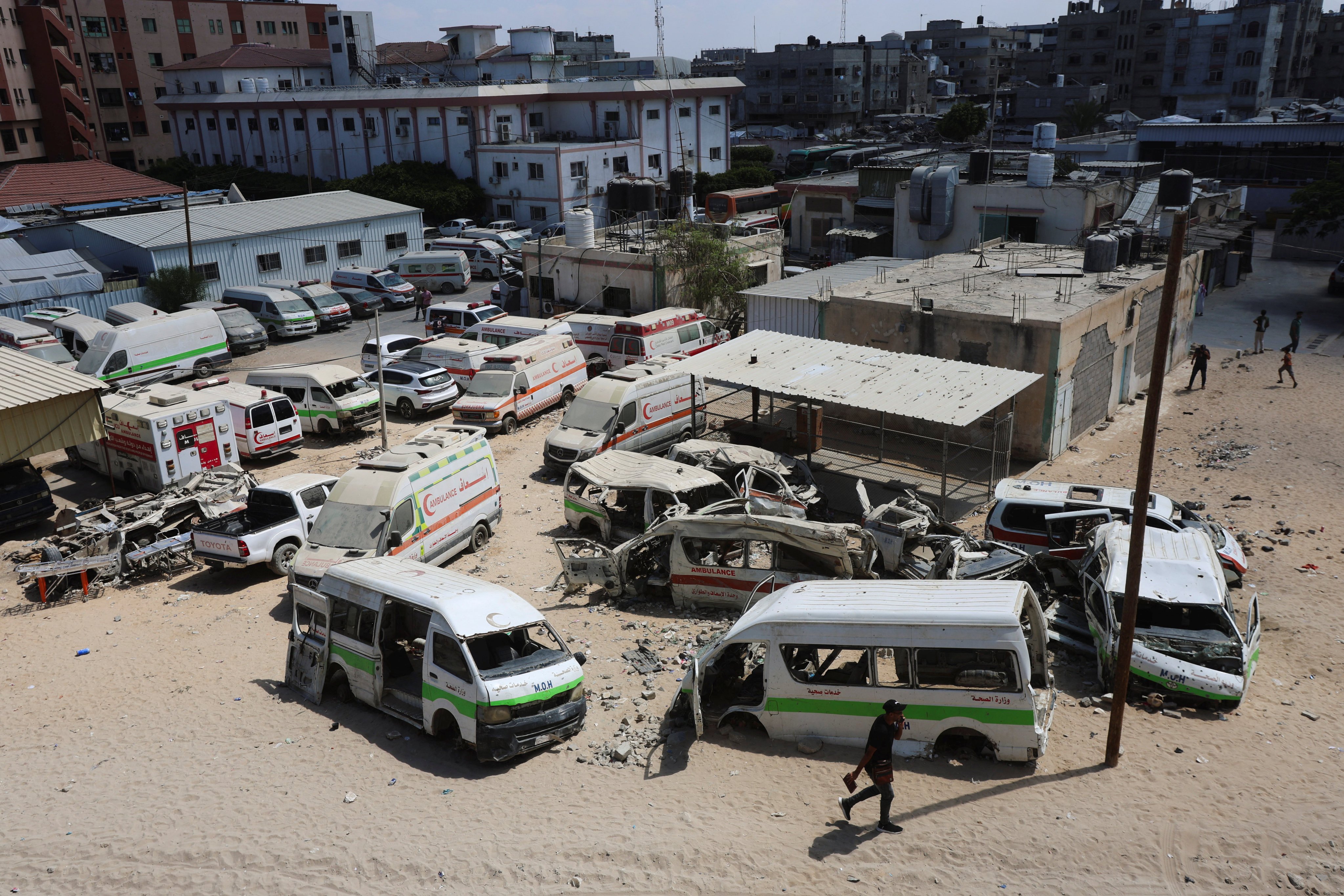 A Palestinian man walks near damaged ambulances and vehicles, amid shortages of fuel and oil needed to run the generators, at Nasser Hospital in Khan Younis, in the southern Gaza Strip, on September 3. Photo: Reuters