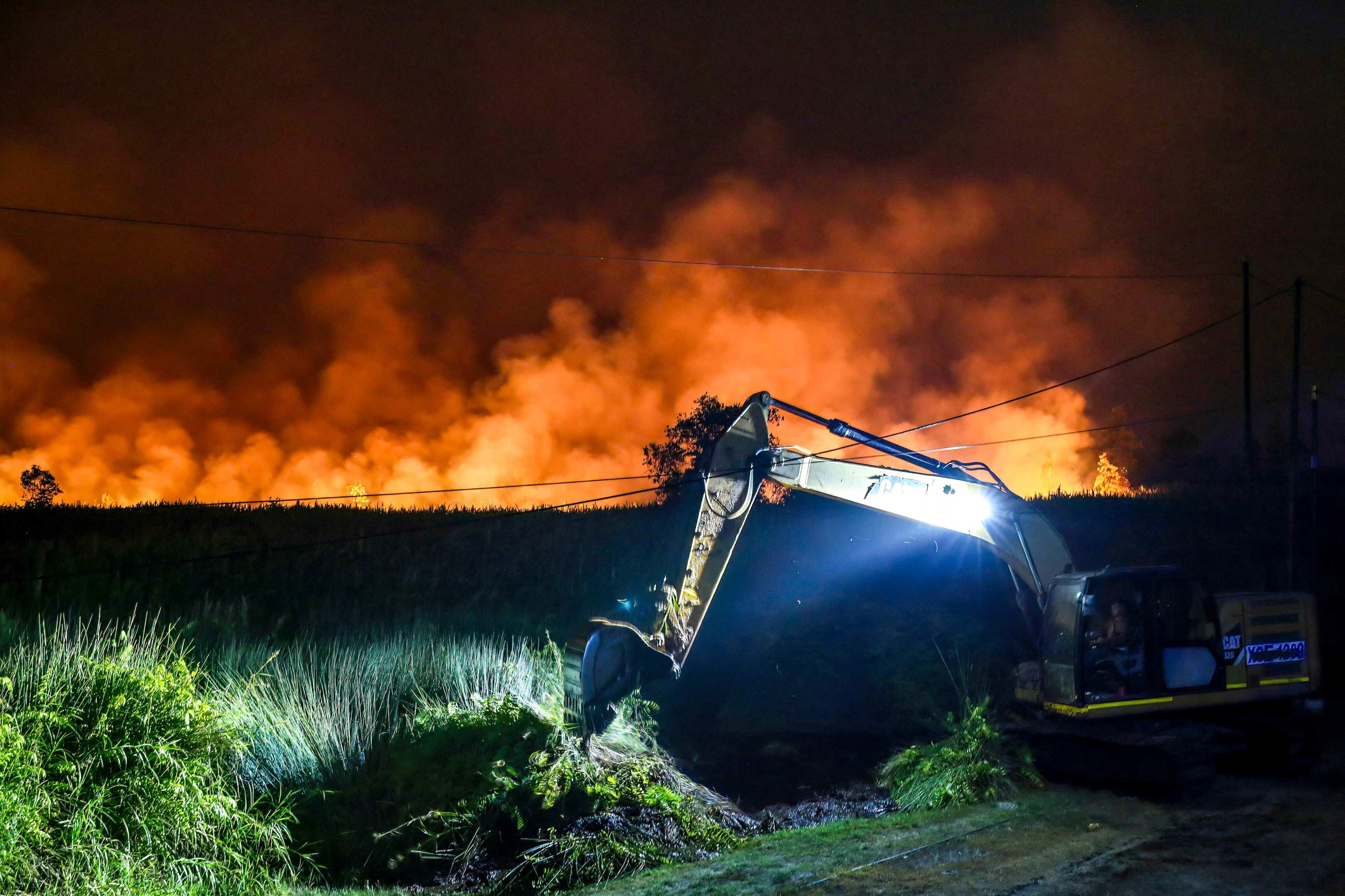 An excavator digs a trench to create a boundary to prevent a wildfire from spreading in Central Kalimantan, Inonesia in August. Photo: AFP