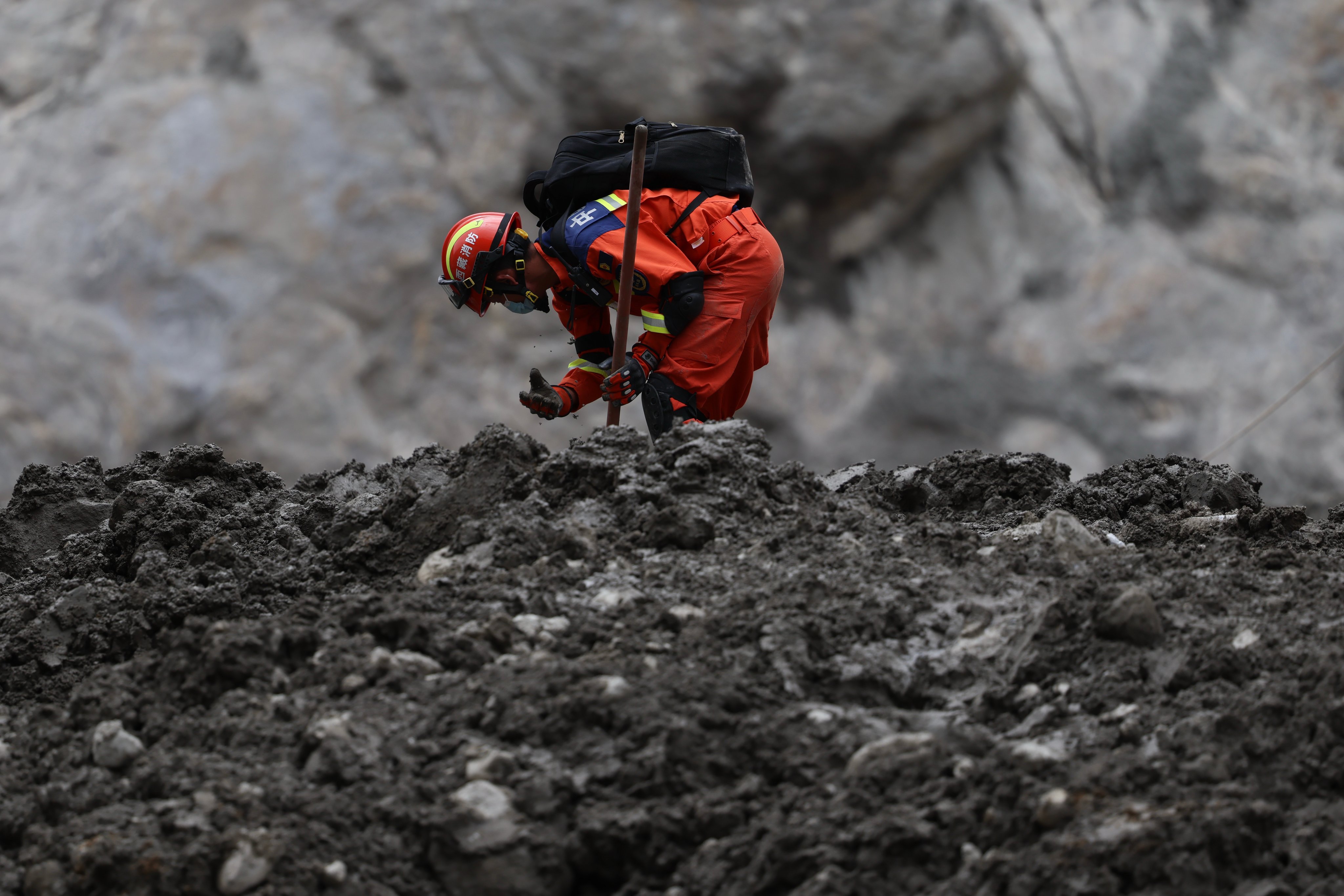 A worker uses his hand to dig during a search and rescue operation at the area that was once Gyirong Port, now wiped from existence, in China’s Tibet autonomous region. Photo: AP