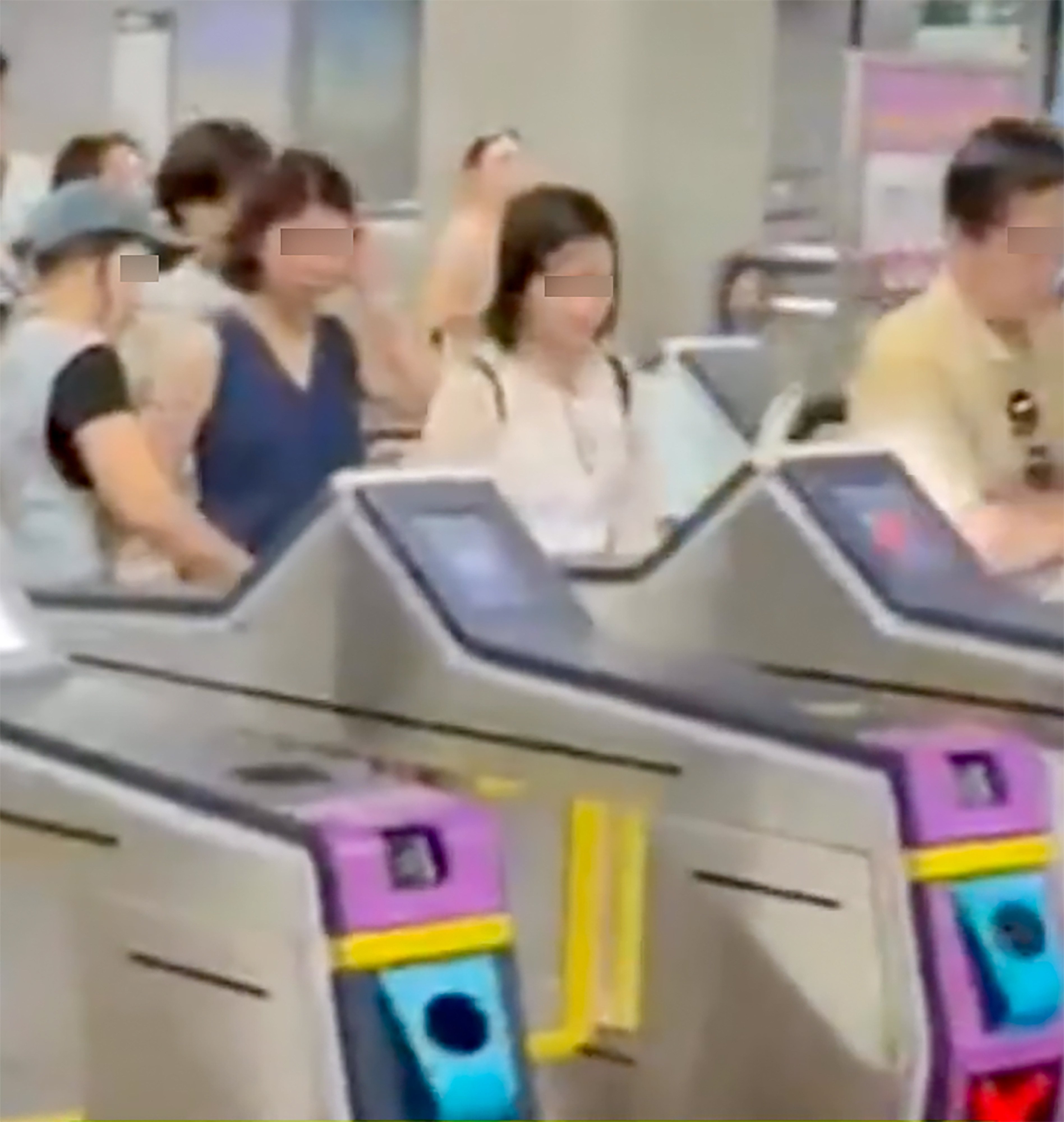 Footage shows a woman (left), believed to be a tour guide, tapping her card at an exit gate as a group follows closely behind in single file to leave the station. Photo: Threads/samilivehk