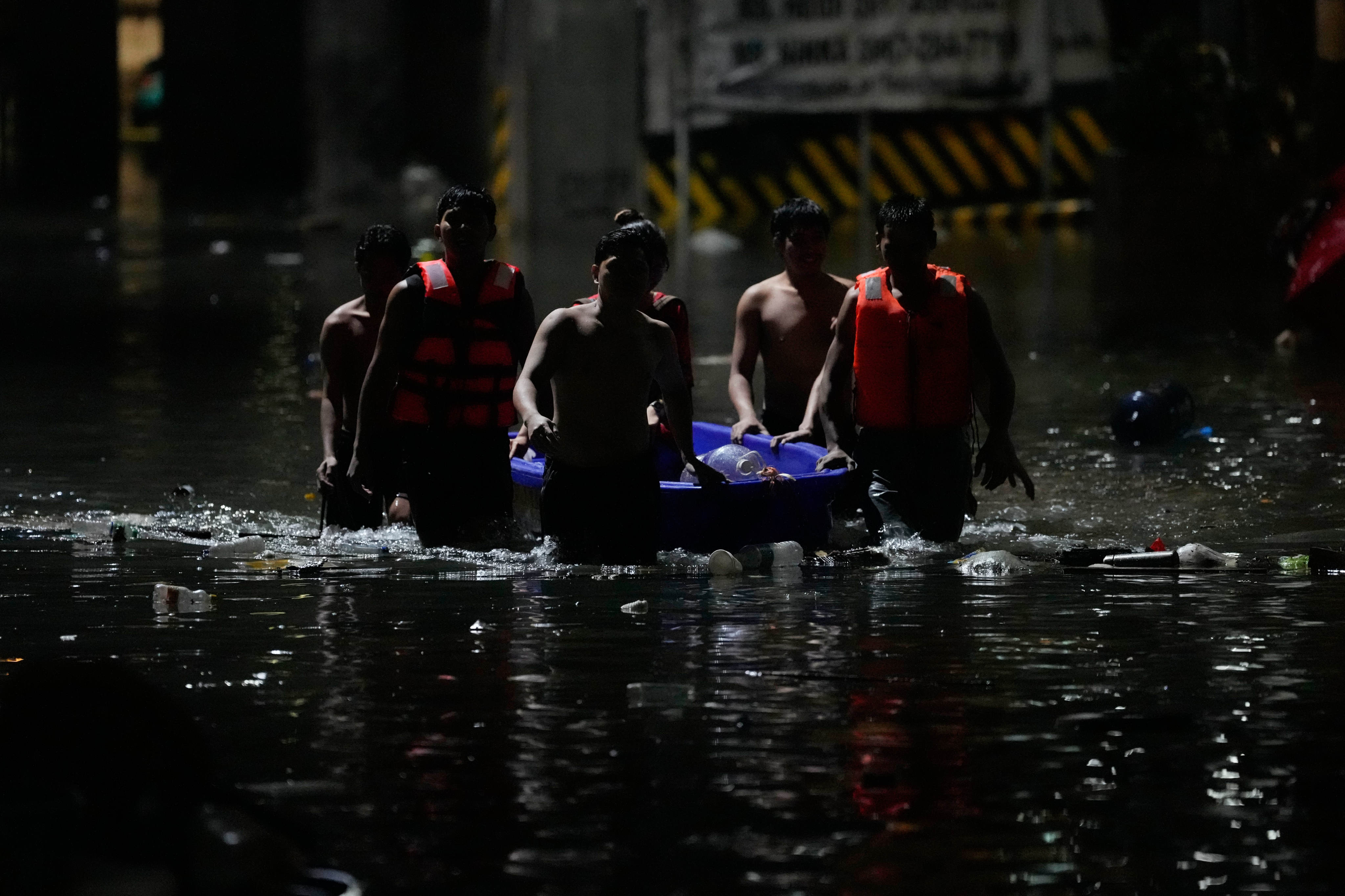 Men push a small boat along a flooded street after intense monsoon rains in Quezon City, the Philippines, last month. Photo: AP