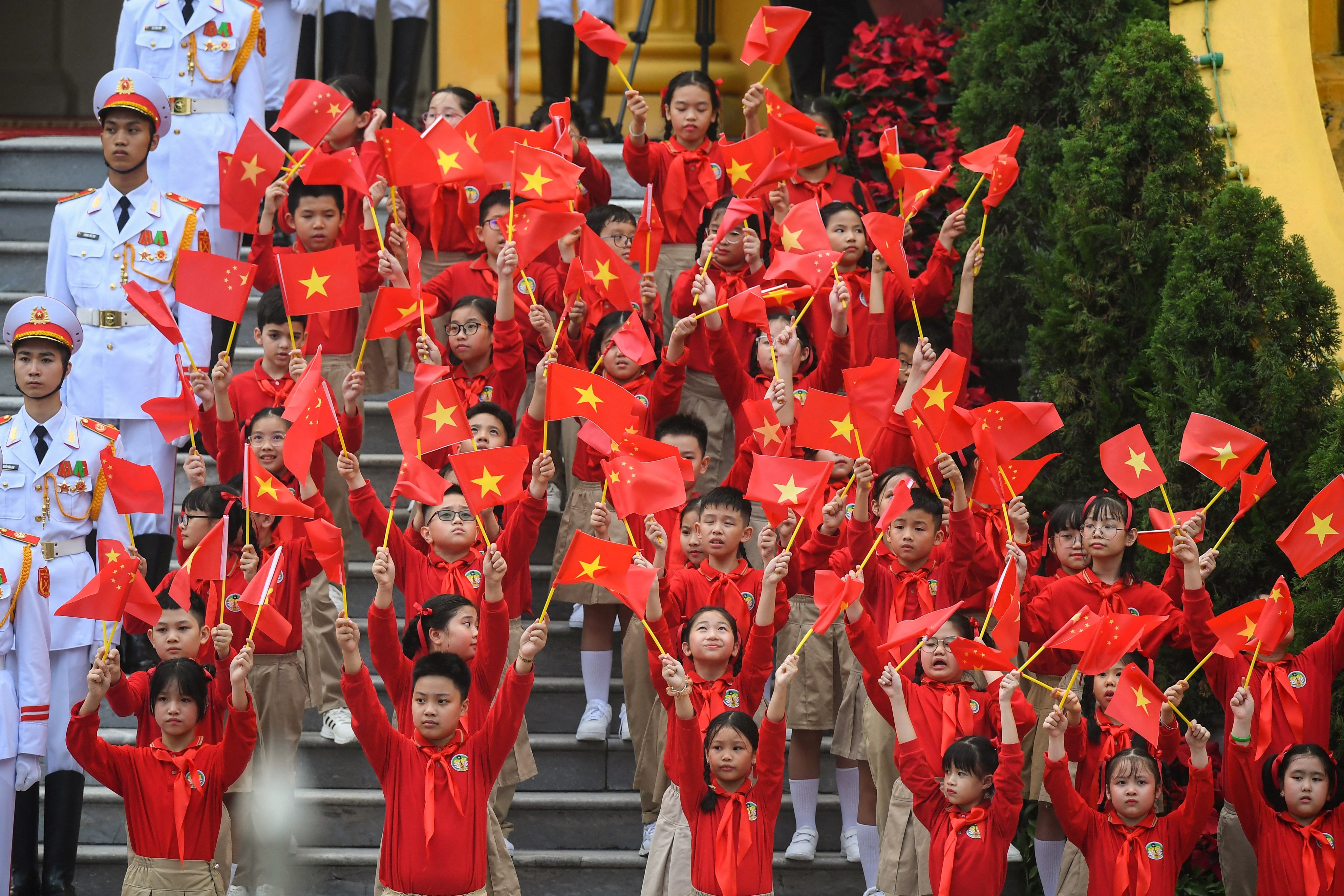 Children wave Vietnamese and Chinese flags during a welcome ceremony for China’s President Xi Jinping in Hanoi in 2023. Photo: AFP