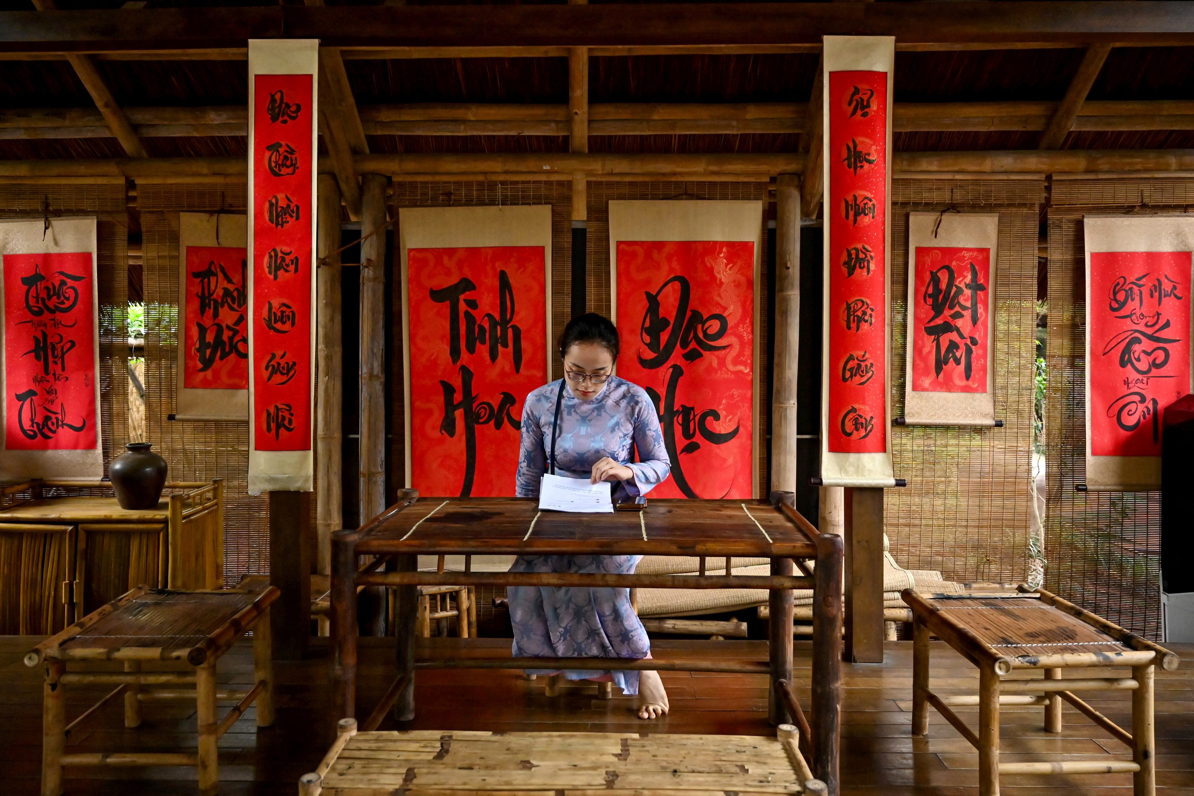 A woman reads a document inside the Temple of Literature, a temple dedicated to ancient Chinese philosopher Confucius, in Hanoi, Vietnam last year. Photo: AFP