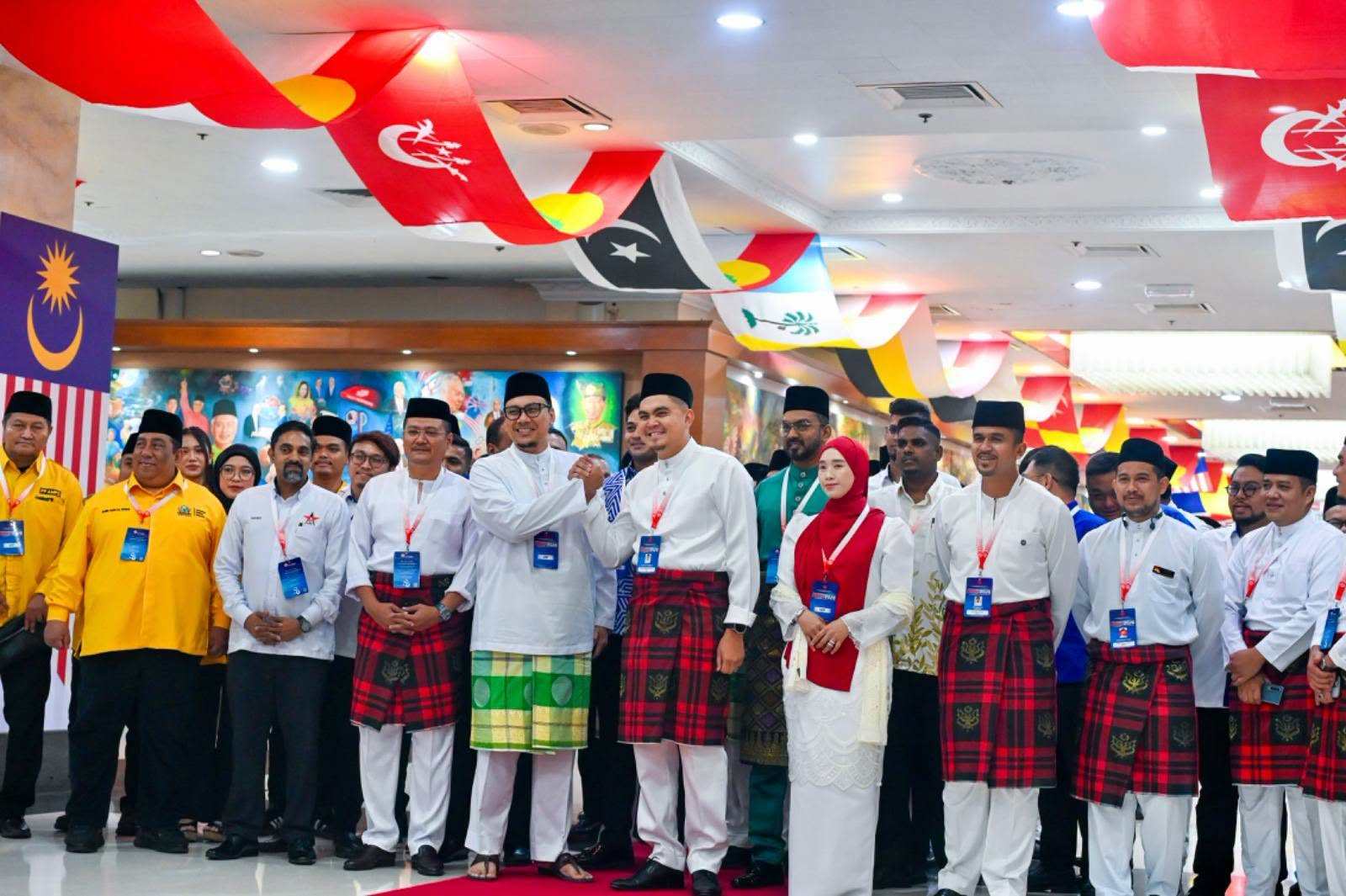 Umno delegates welcome visitors from PAS at the annual assembly on Friday. Photo: Facebook/mediaumnomalaysia