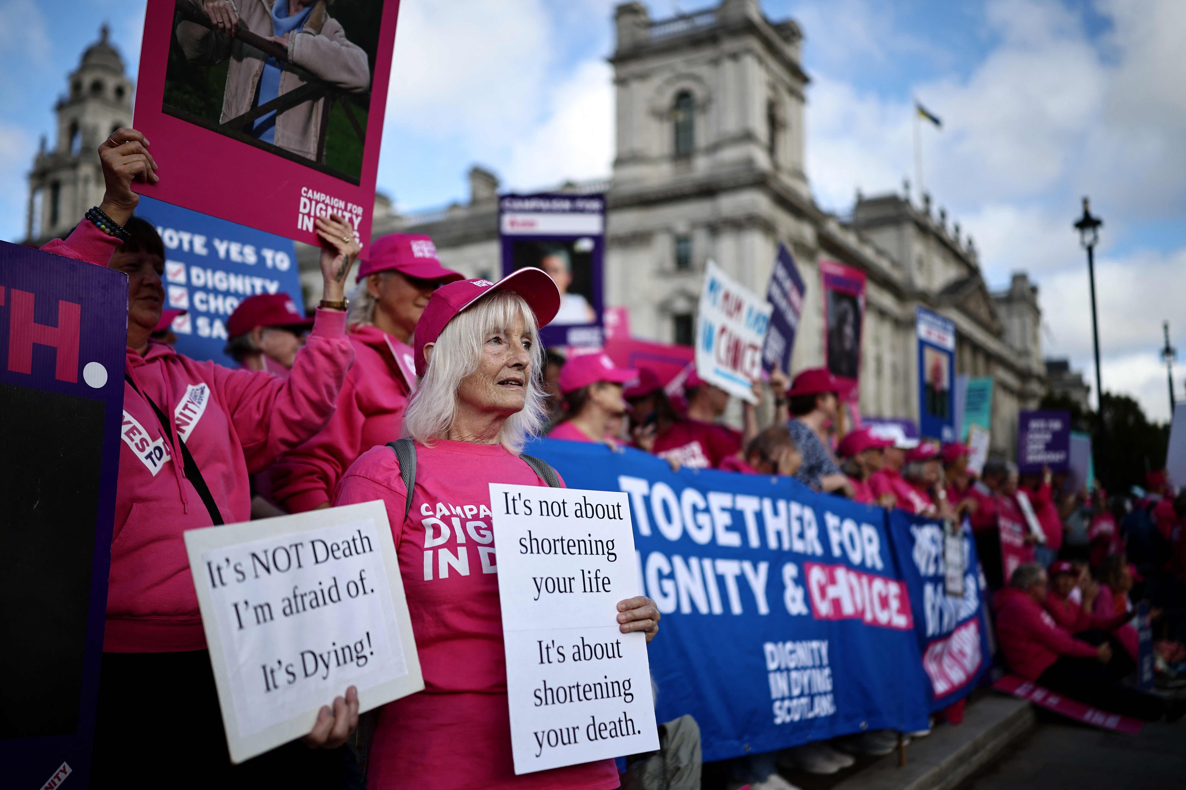 A campaigner for a change in the law on assisted dying holds a placard outside The Palace of Westminster, home to the Houses of Parliament in central London on Friday. Photo: AFP