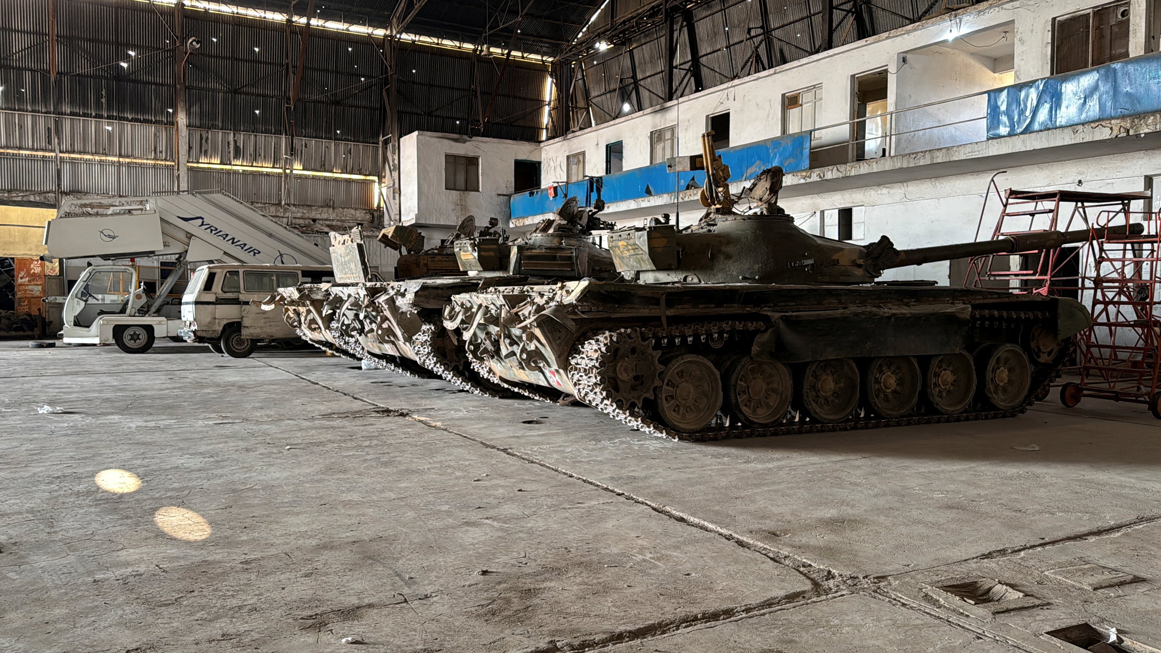 Abandoned tanks are seen parked in an aircraft hangar at a military airport in the suburb of Mezzeh, Syria. Photo: Reuters