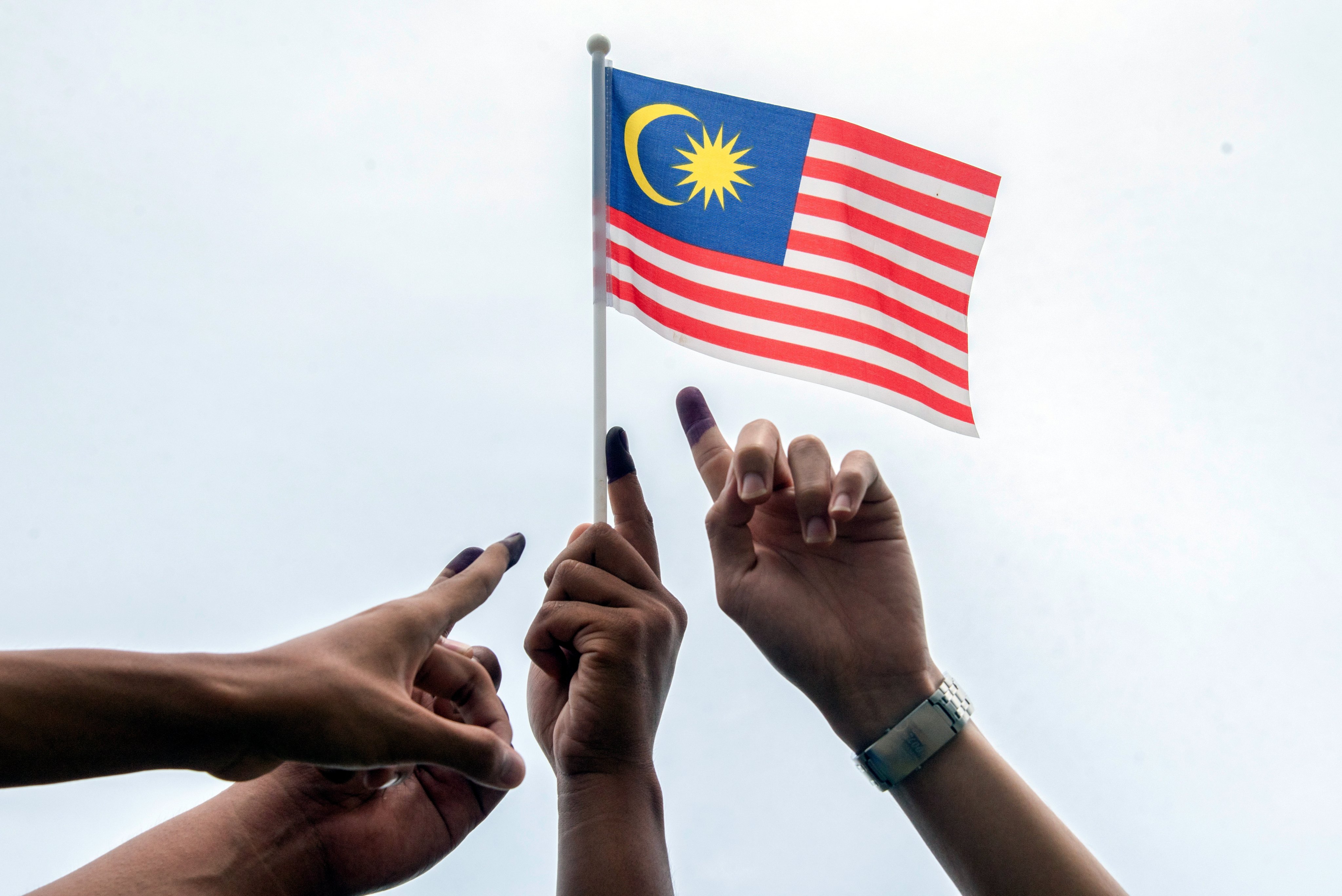 Malaysian voters show their fingers dipped in ink after voting during the 2022 general election. Photo: dpa