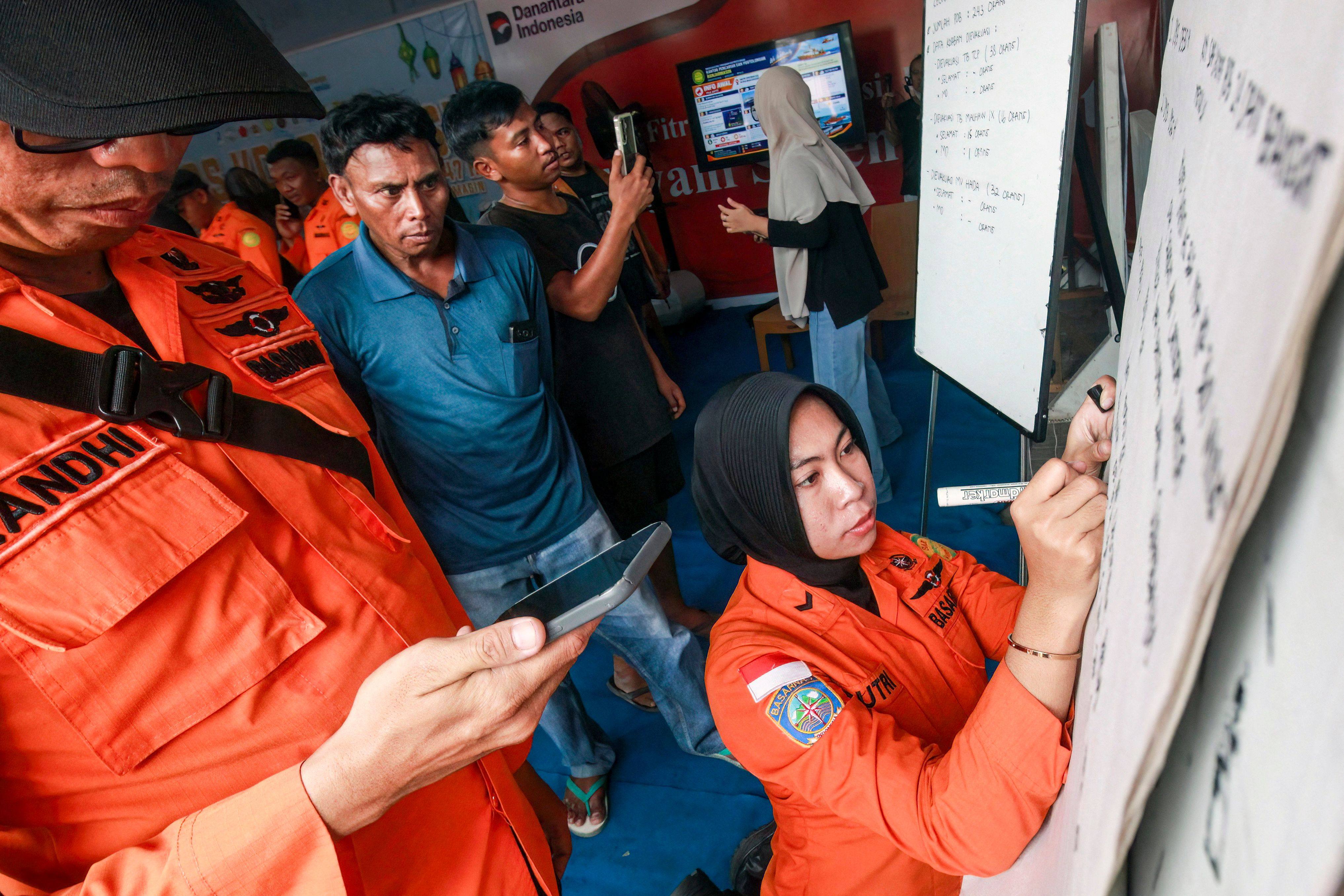 Relatives of affected passengers look on as an officer writes updates on a whiteboard about the stricken ship at Trisakti Bandarmasih Port in Banjarmasin, South Kalimantan, Indonesia, on Sunday. Photo: AFP