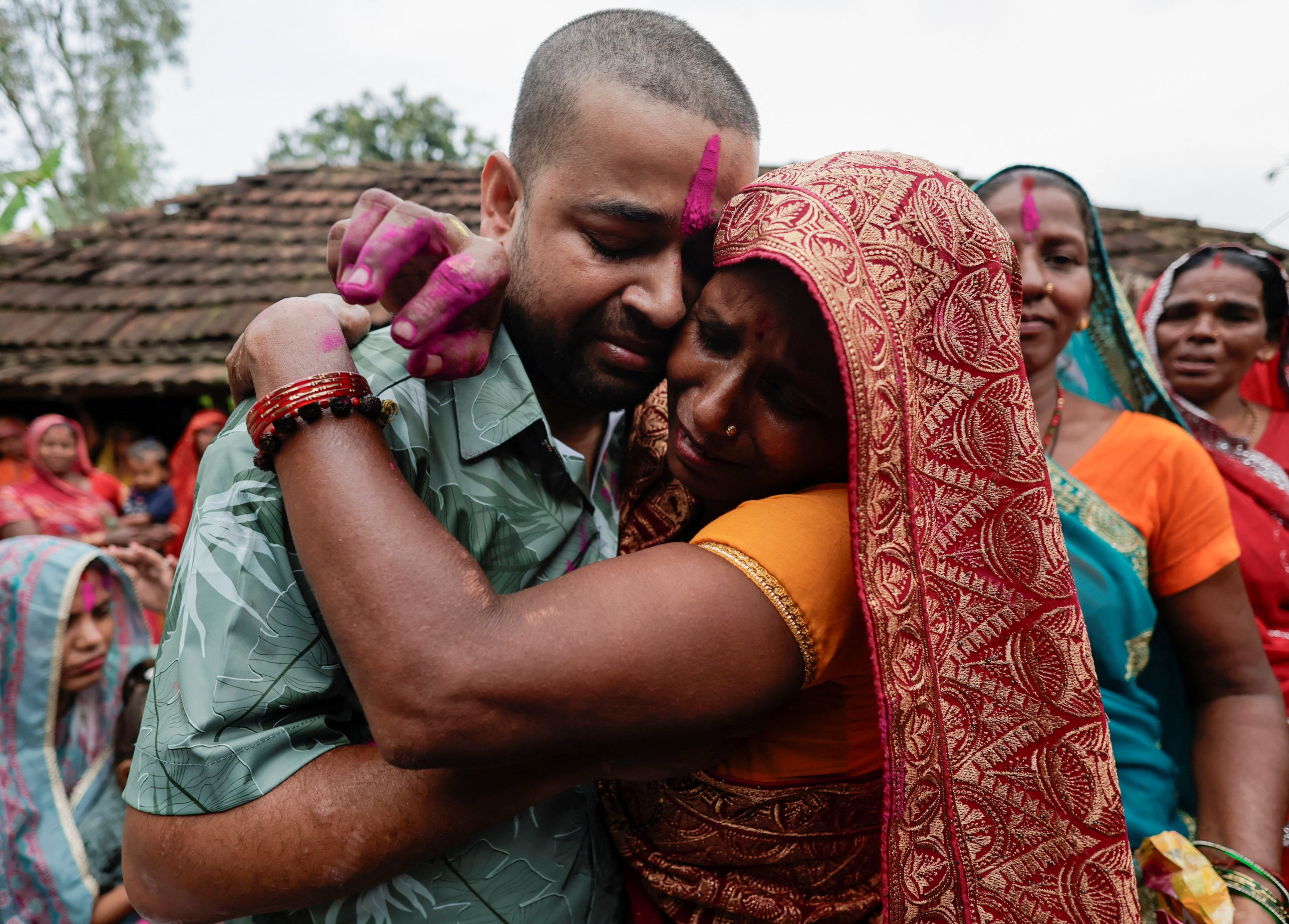 Kapur Devi Sah, mother of Sanjay Sah, a survivor pulled out alive after spending nine days trapped in a hydropower station tunnel following flash floods and a mudslide, gets emotional as she hugs her son upon his arrival at their house in Tilathi Koiladi village in Saptari District, Nepal, September 13, 2026. REUTERS/Navesh Chitrakar