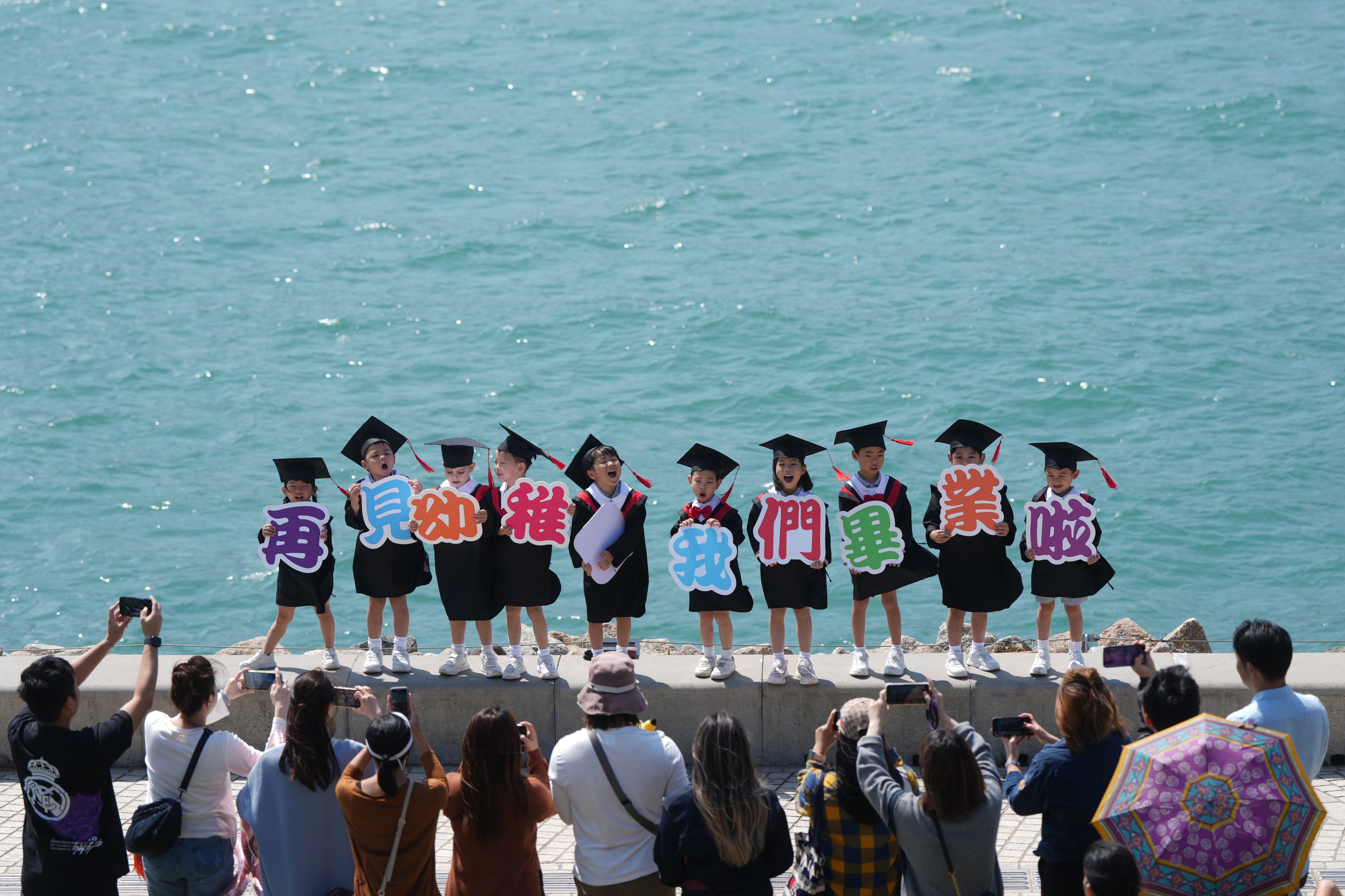 Kindergarten graduates poses for pictures at West Kowloon Cultural District. Photo: Sam Tsang