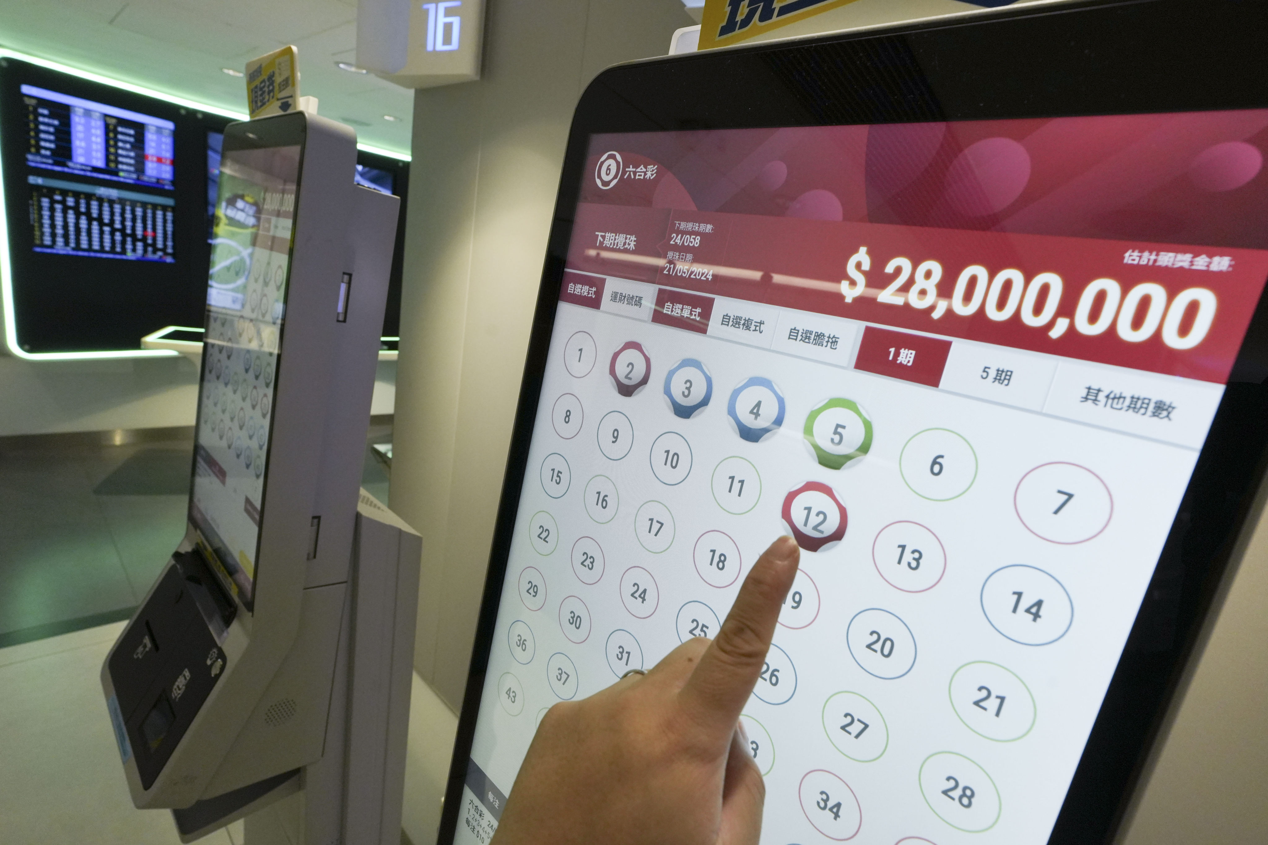 People select their favourite numbers via a kiosk for a Mark Six jackpot at a Hong Kong Jockey Club betting branch in Causeway Bay. Photo: Sun Yeung