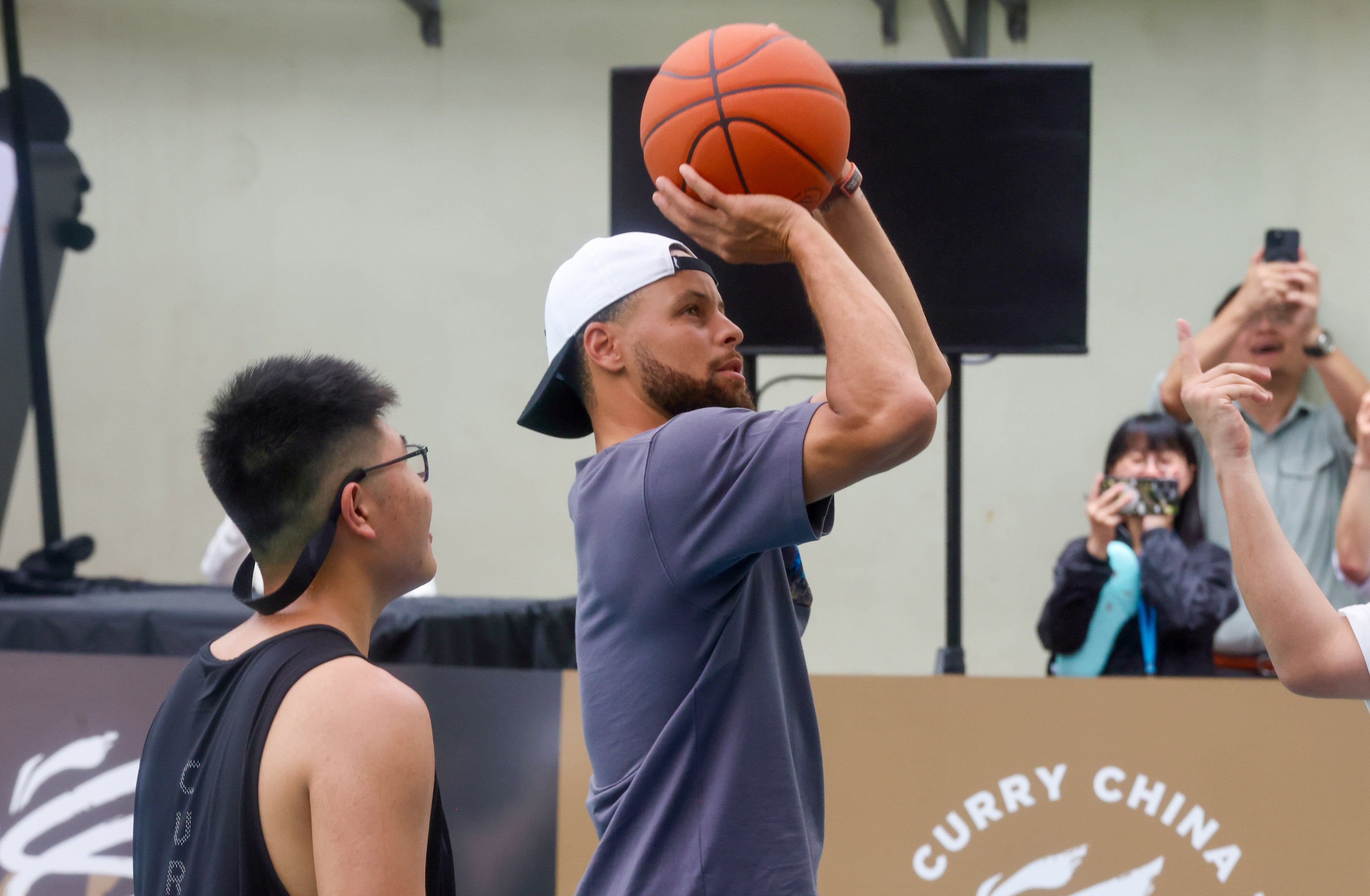 NBA star Stephen Curry takes a shot during his visit to Shun Tak Fraternal Association Leung Kau Kui College Estate Secondary School. Photo: Jonathan Wong