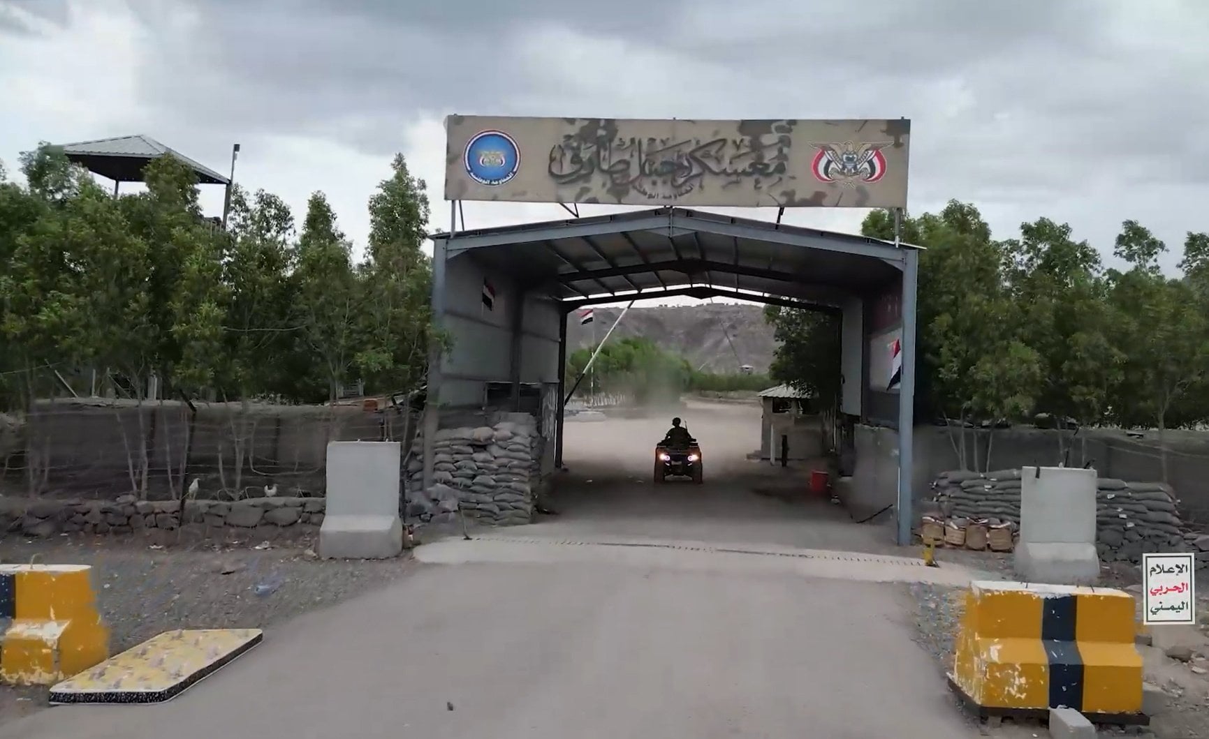A Houthi fighter at the entrance to a seized camp. Photo: Houthi Military Media via EPA