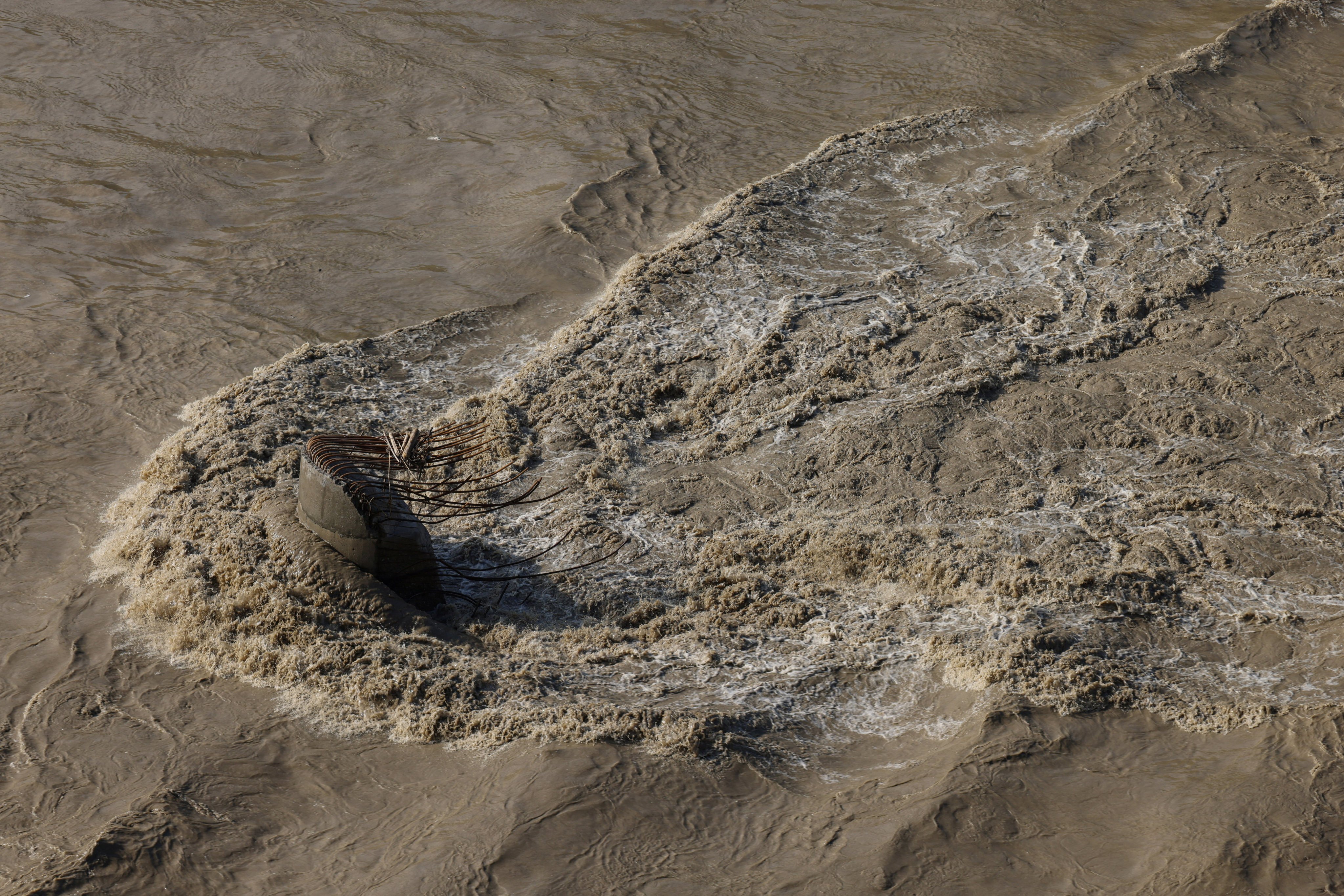 Water flows past the remains of a bridge pier in Dhading district, Nepal, on Monday after the structure is washed away by deadly flash floods and a mudslide. Photo: Reuters
