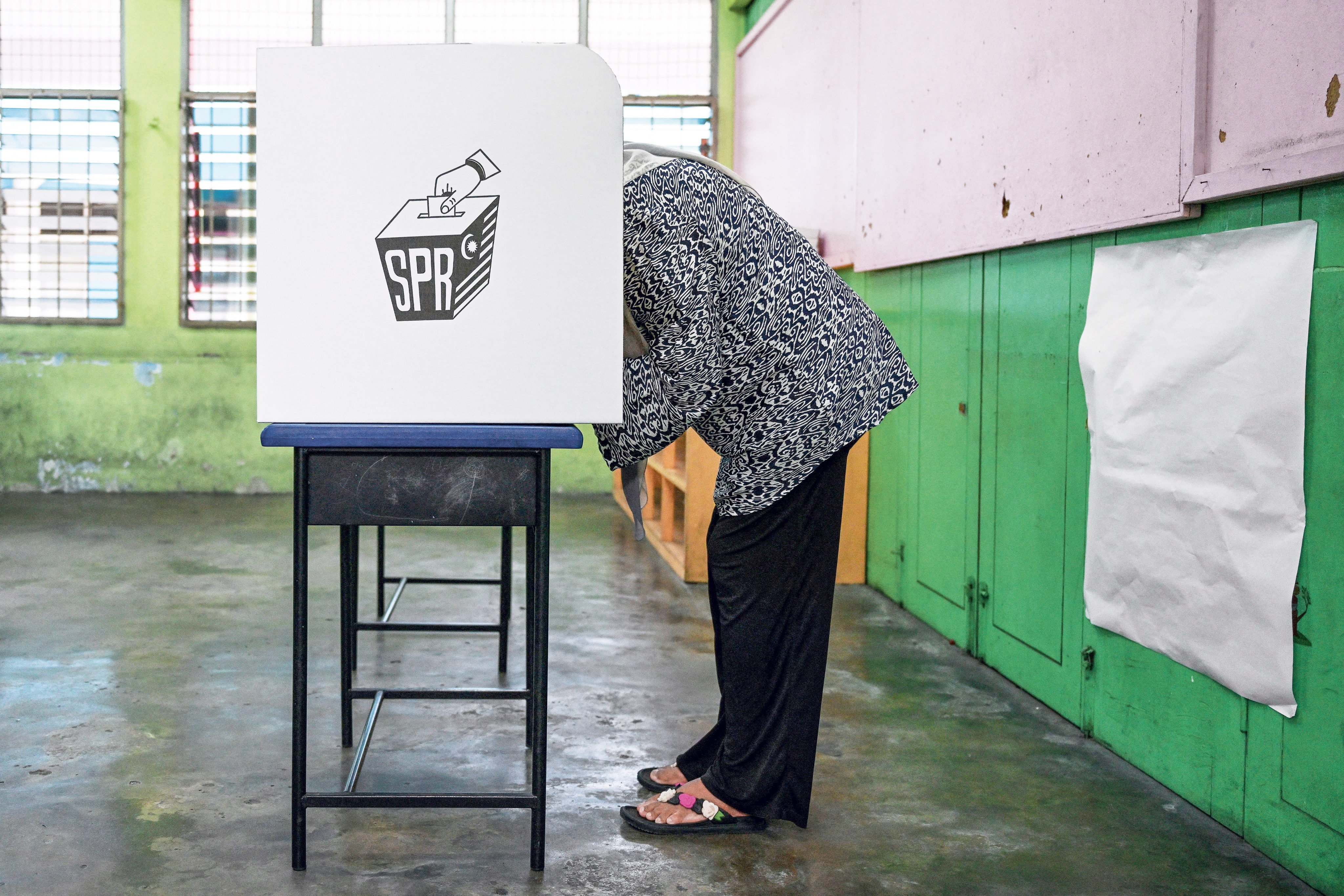 A woman casts her vote at a polling station during a state election in Malaysia in 2023. Photo: AFP