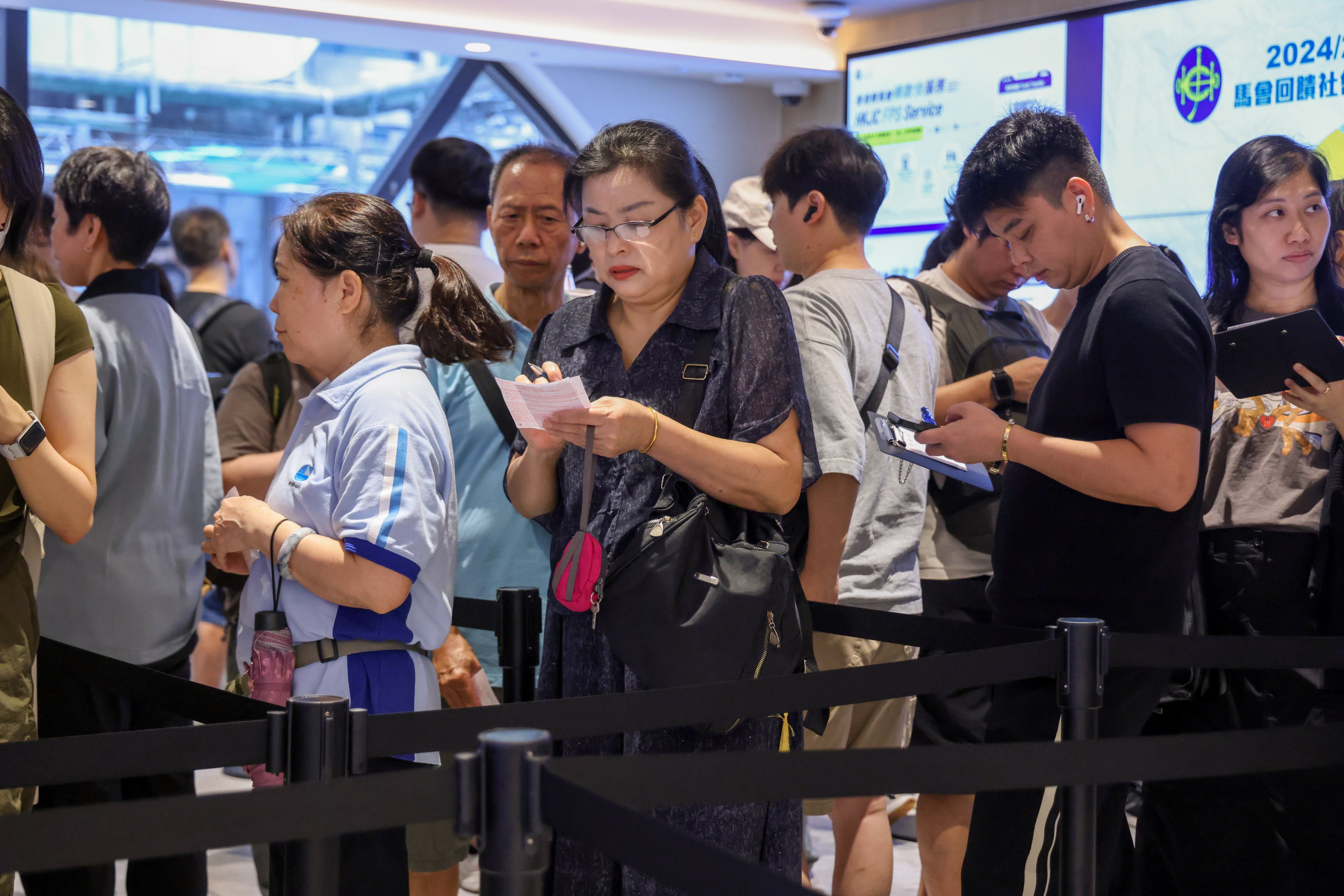 A long queue forms outside the Jockey Club’s Stanley Street betting branch in Central. Photo: Nora Tam