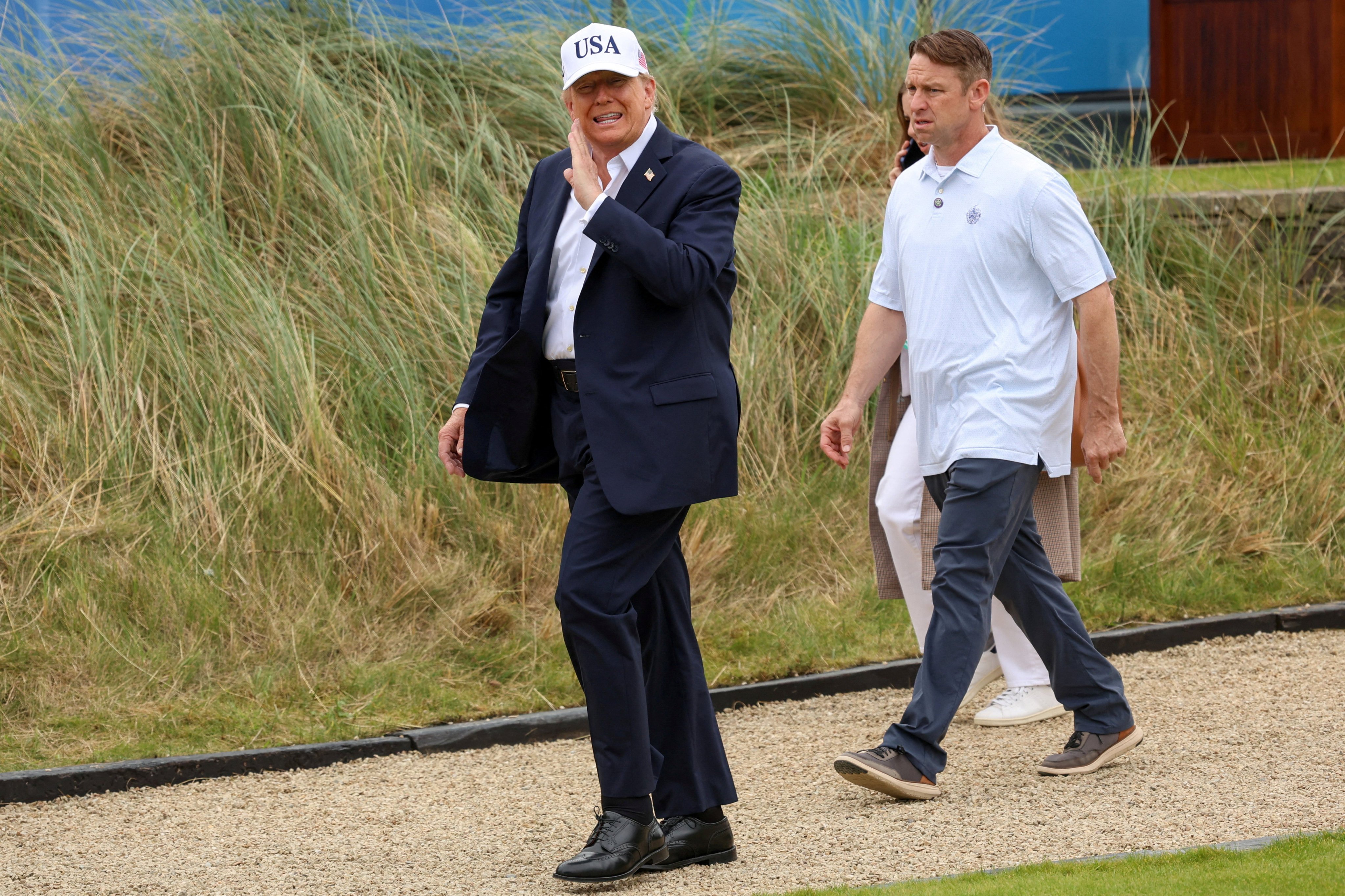 US President Donald Trump walks to the first tee at the Amgen Irish Open on Sunday. Photo: Reuters