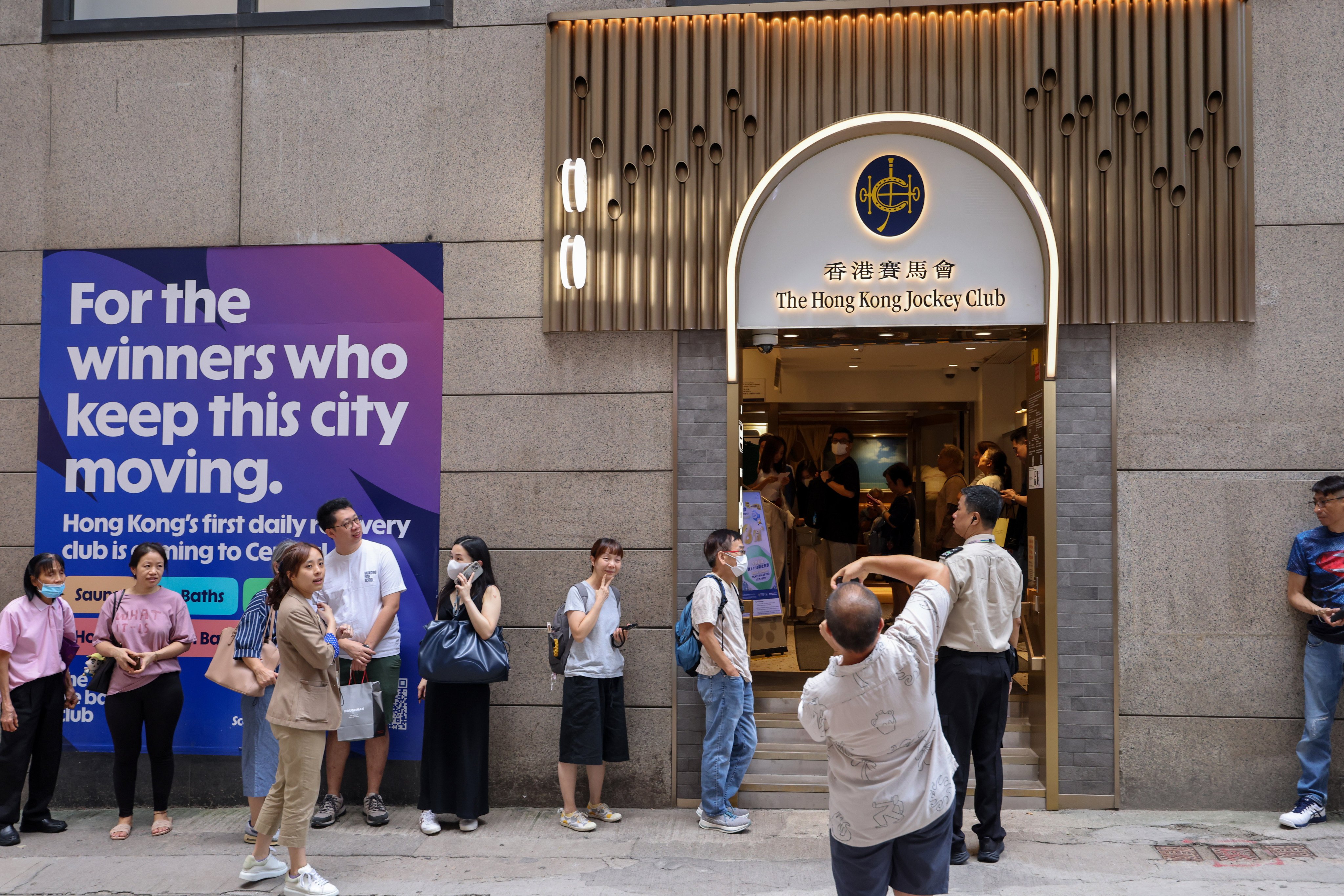 Long queues form outside a Jockey Club betting branch on Stanley Street. Photo: Nora Tam